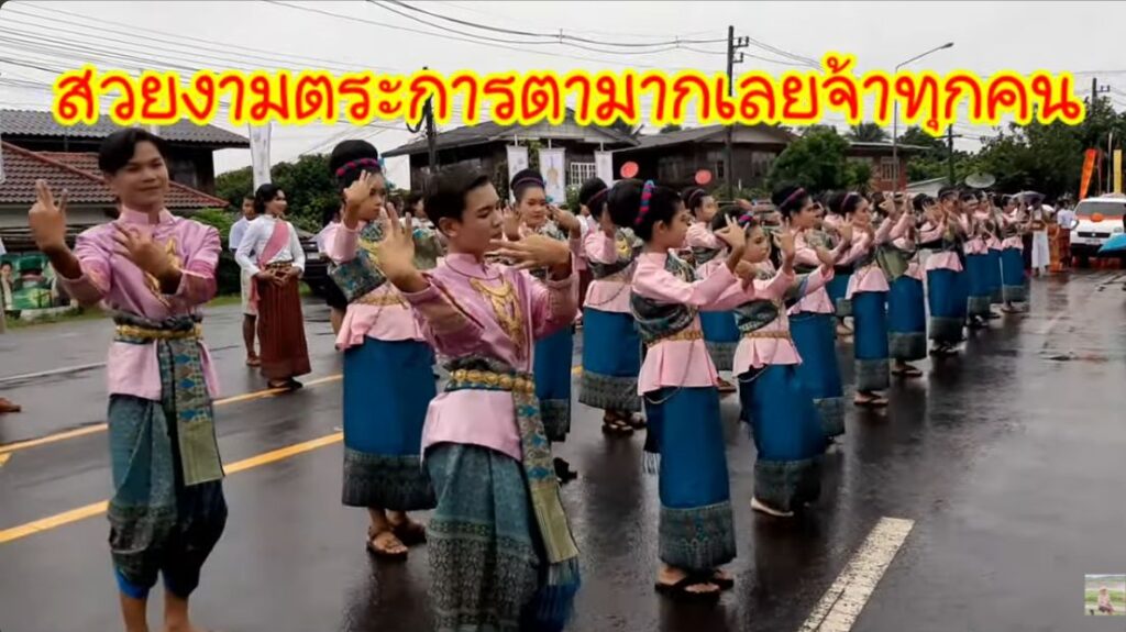 ขบวนนางรำในชุดพื้นเมืองเคลื่อนตามถนนในงานปี 2566