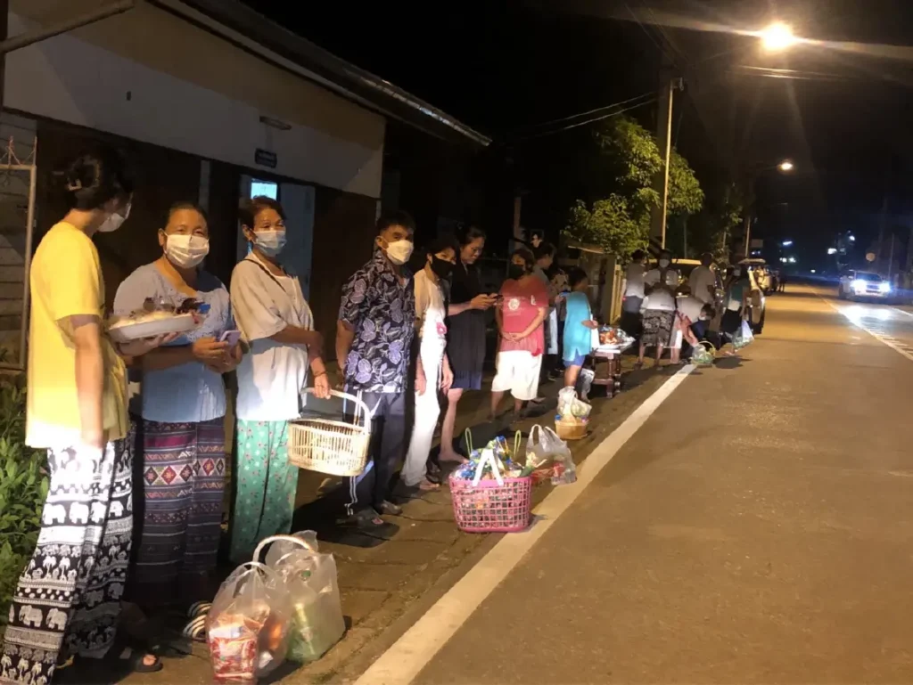 ประชาชนเตรียมของใส่บาตรรอตลอดสองฝั่งถนน ปี 2565