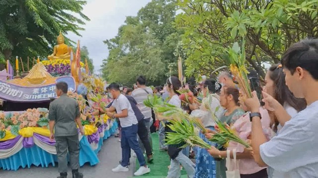 ประชาชนยกช่อดอกเข้าพรรษาถวายในระหว่างขบวนตักบาตรปี 2568