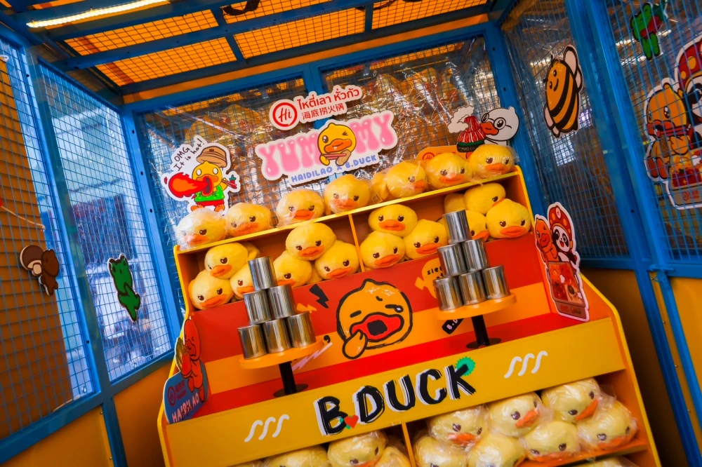 บูธเกมที่วางกระป๋องซ้อนและตุ๊กตาเป็ด B.Duck ในกิจกรรมเซ็นทรัลเวิลด์ ปี 2568