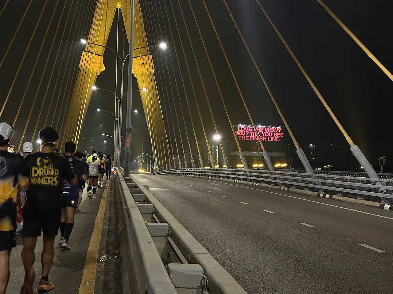 ผู้ร่วมงานวิ่งเดินตามพื้นที่ริมสะพานพระราม 8 ขณะยังมืด