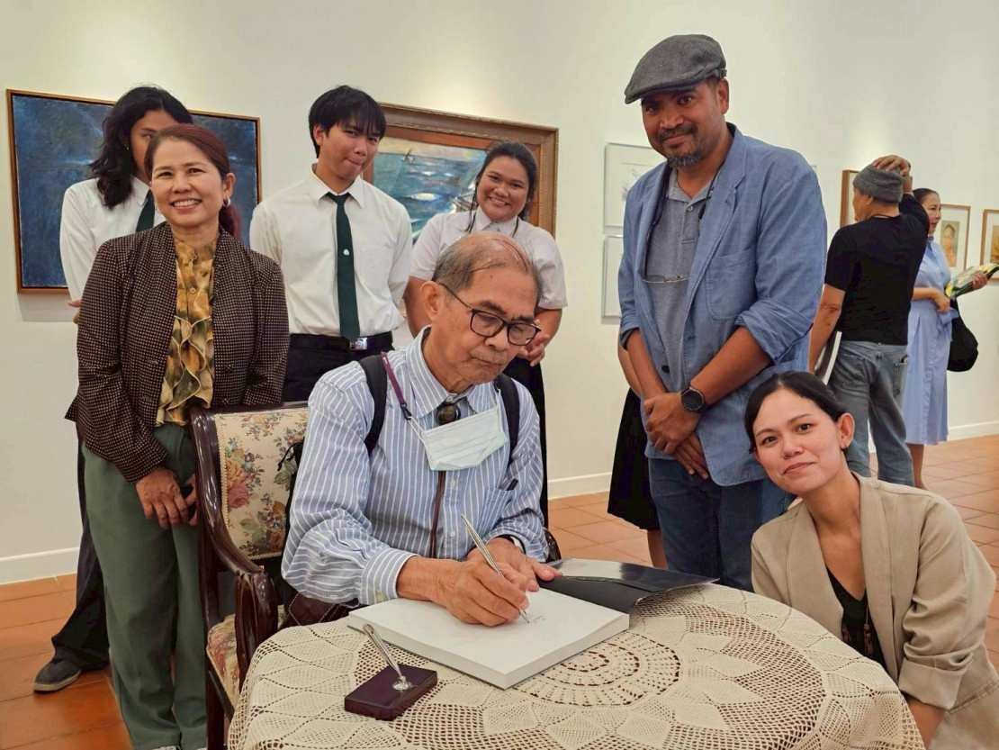 ภาพศิลปิน สวัสดิ์ ตันติสุข ลงนามในหนังสือนิทรรศการเชิดชูเกียรติศิลปินอาวุโส ปี 2568