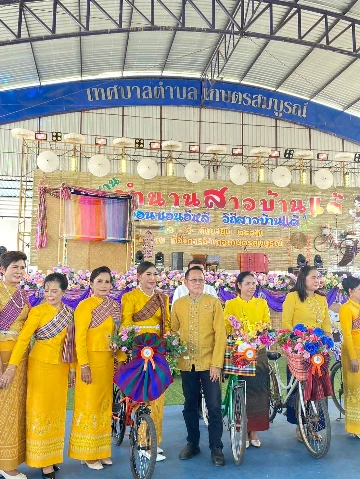 ผู้ร่วมงานแต่งกายชุดผ้าไทยยืนถ่ายภาพในงานสืบสานตำนานสาวบ้านแต้ปี 2567