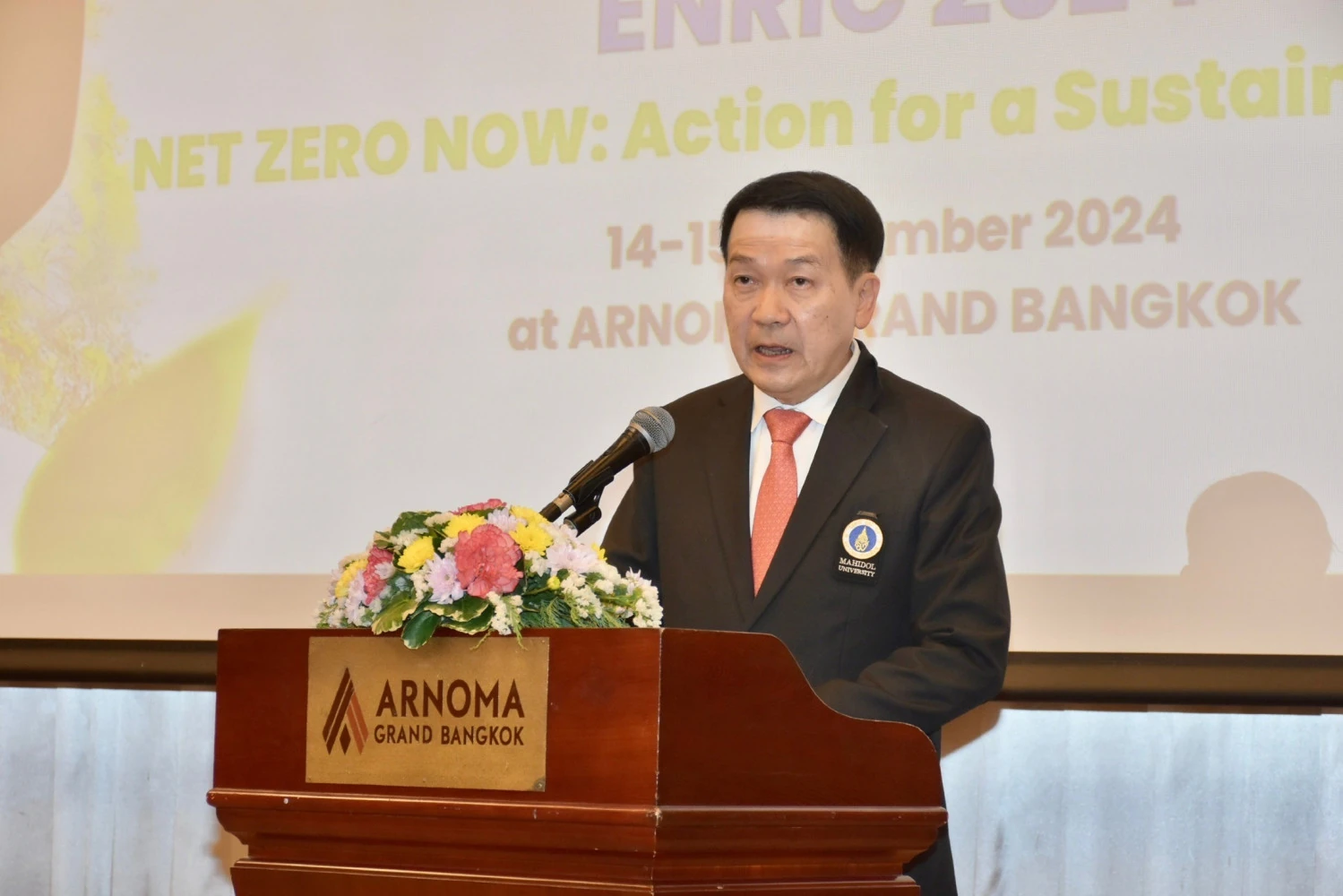 วิทยากรกล่าวบนเวทีการประชุม ENRIC 2024 ที่มีป้ายครั้งที่ 5
