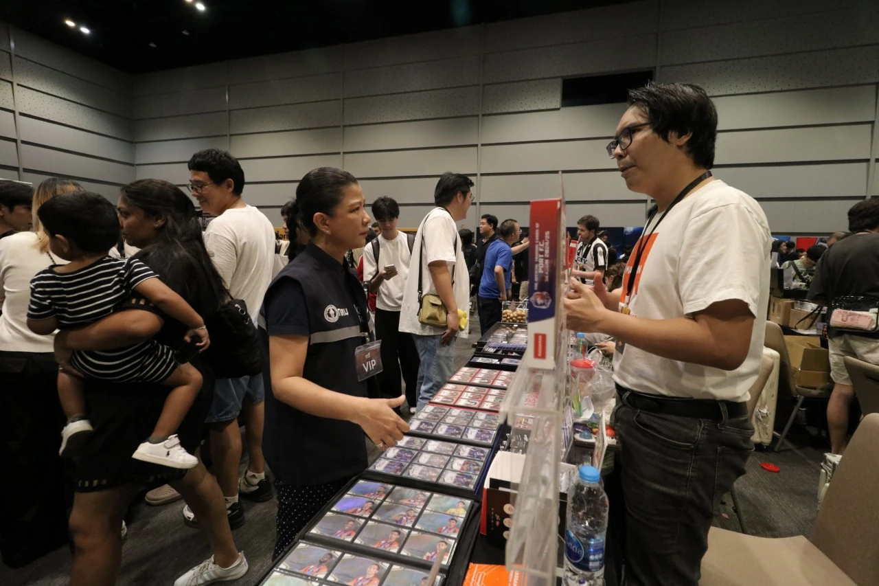 ผู้เข้าร่วมพูดคุยและเลือกชมการ์ดสะสมที่บูธใน Bangkok International Card Show 2025