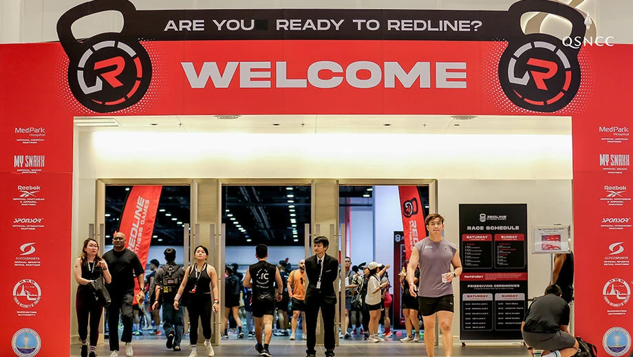 ผู้เข้าร่วมเดินผ่านซุ้มต้อนรับ REDLINE Fitness Games Bangkok 2025 ที่ศูนย์ฯ สิริกิติ์