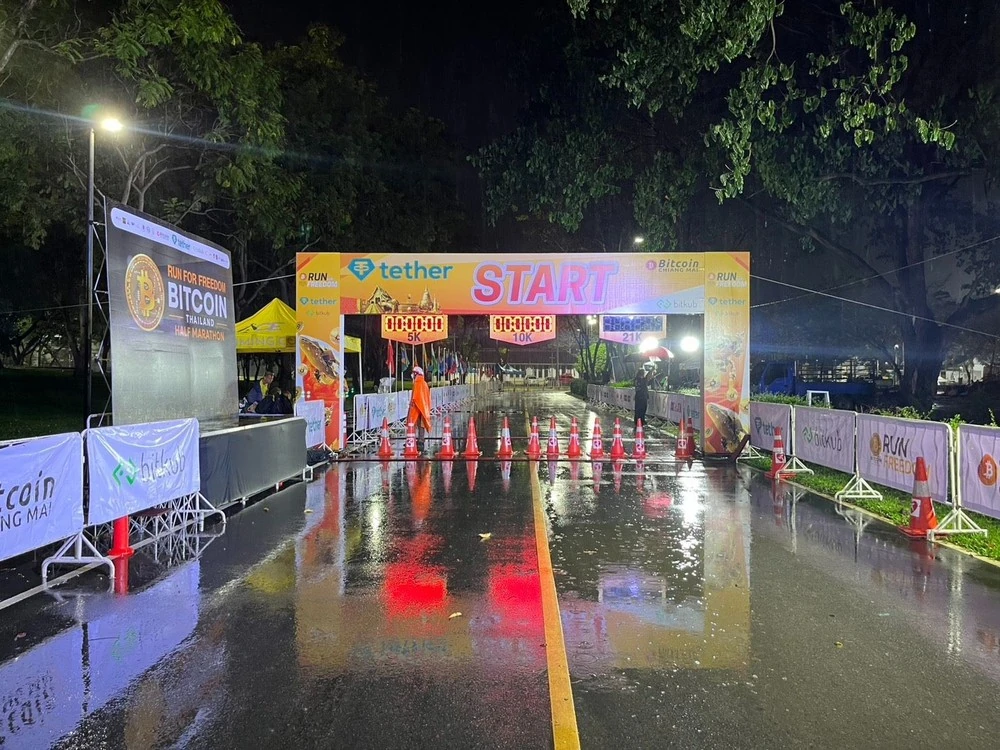 จุดปล่อยตัว Bitcoin Thailand Half Marathon ปี 2568 ในช่วงกลางคืนพร้อมไฟส่องสว่าง