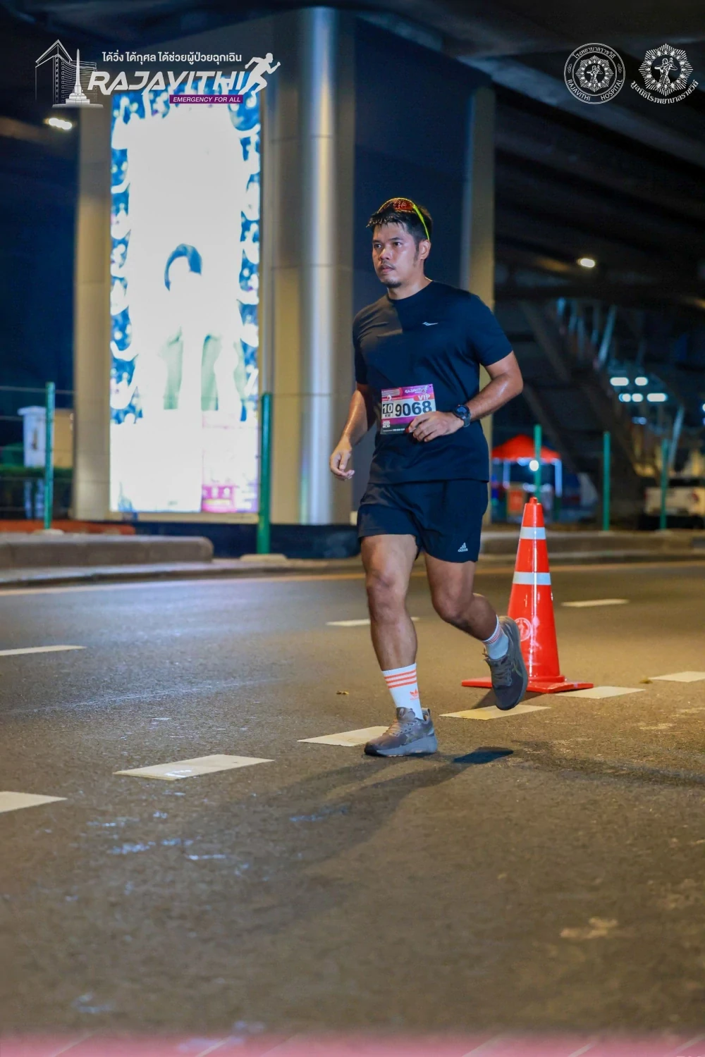 ผู้ร่วมวิ่งผ่านเส้นทางใกล้ซุ้มงาน Rajavithi Run for Life 2568