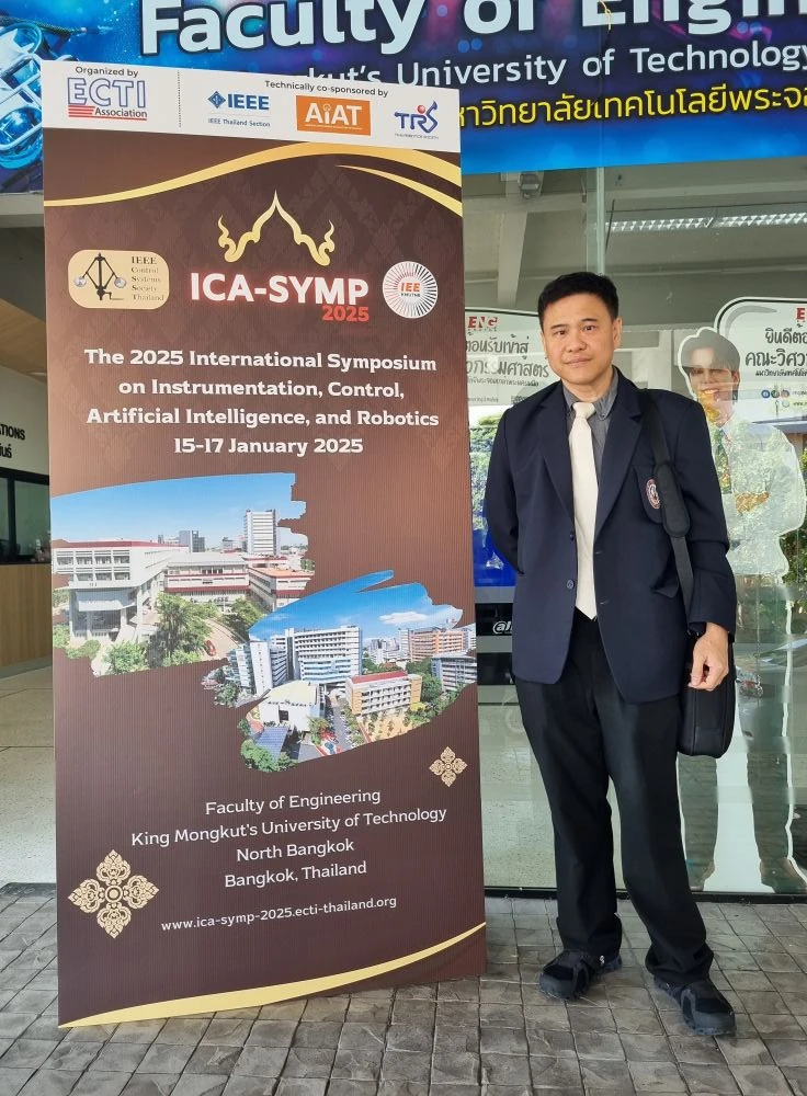 ผู้เข้าร่วมยืนข้างป้ายการประชุม ICA-SYMP 2025 ที่มหาวิทยาลัยเทคโนโลยีพระจอมเกล้าพระนครเหนือ