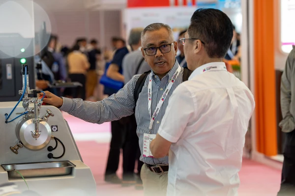 ผู้เข้าชมพูดคุยและดูการสาธิตอุปกรณ์ใน Asia Pacific Coatings Show 2026
