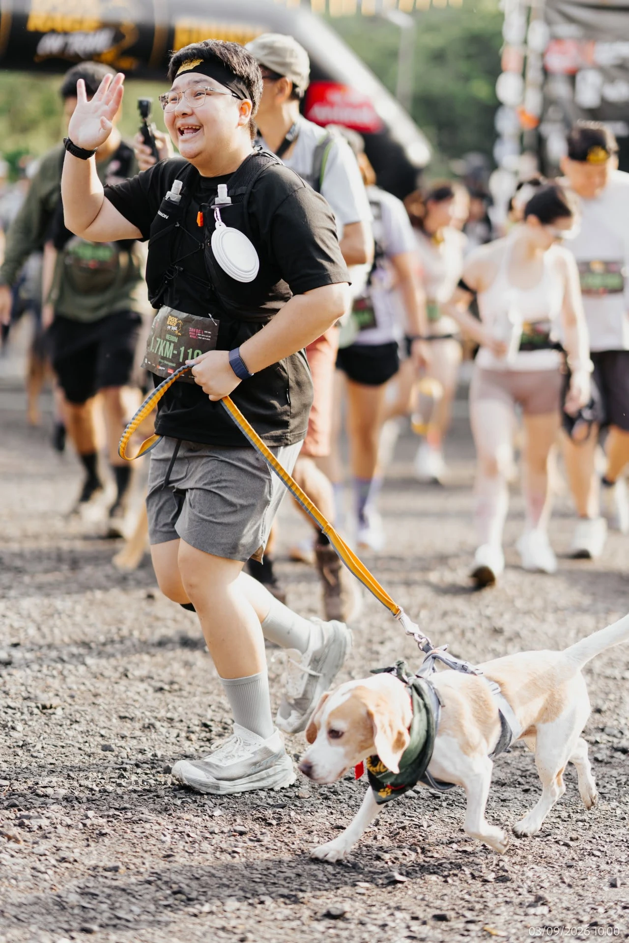 ผู้ร่วมกิจกรรมโบกมือและจูงสุนัขในอัลบั้ม DOX Race on Trail 2026 ของผู้จัด
