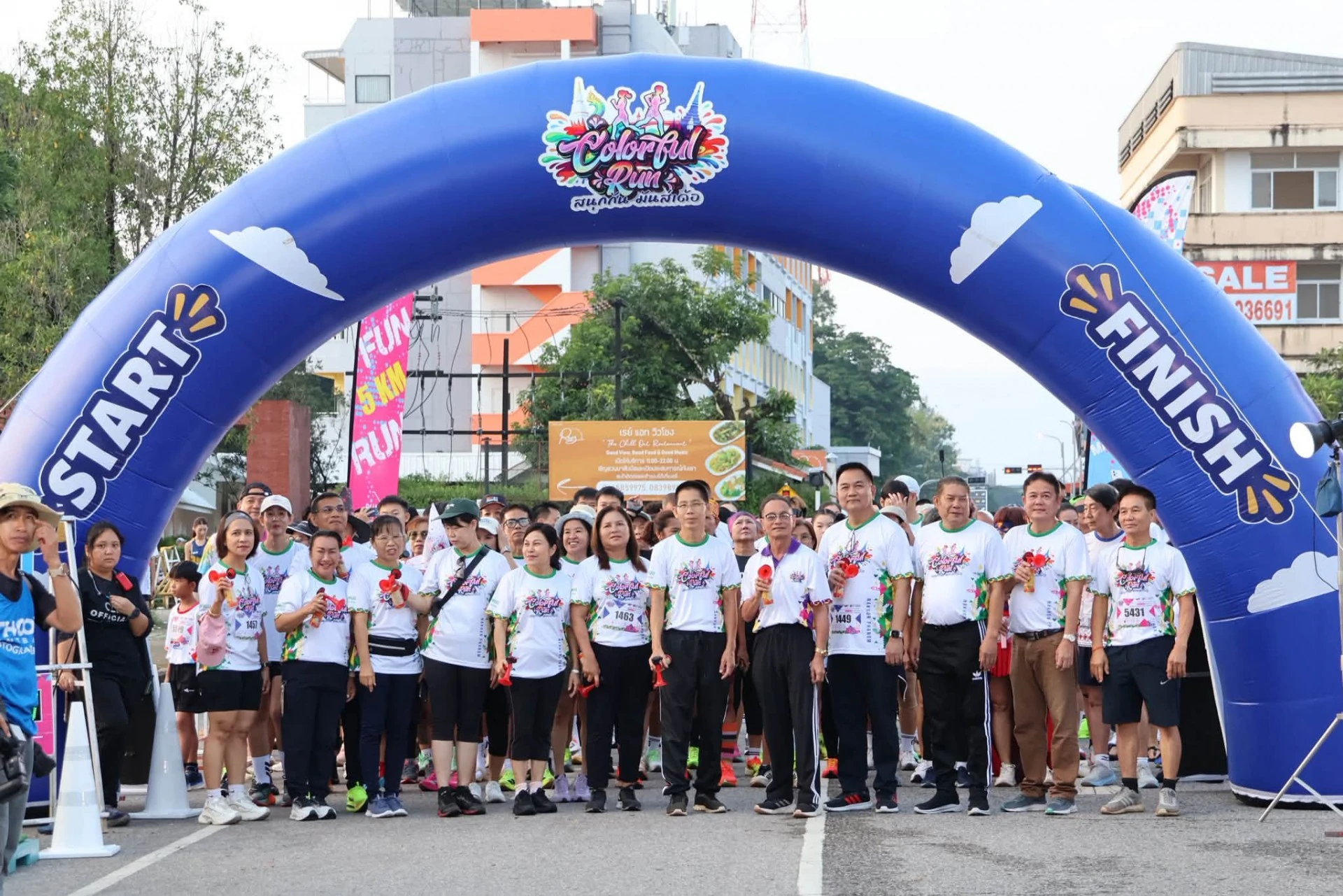 กลุ่มผู้ร่วมงานใต้ซุ้ม START FINISH ของ Colorful Run สนามนครพนม จากรายงานเดียวกัน