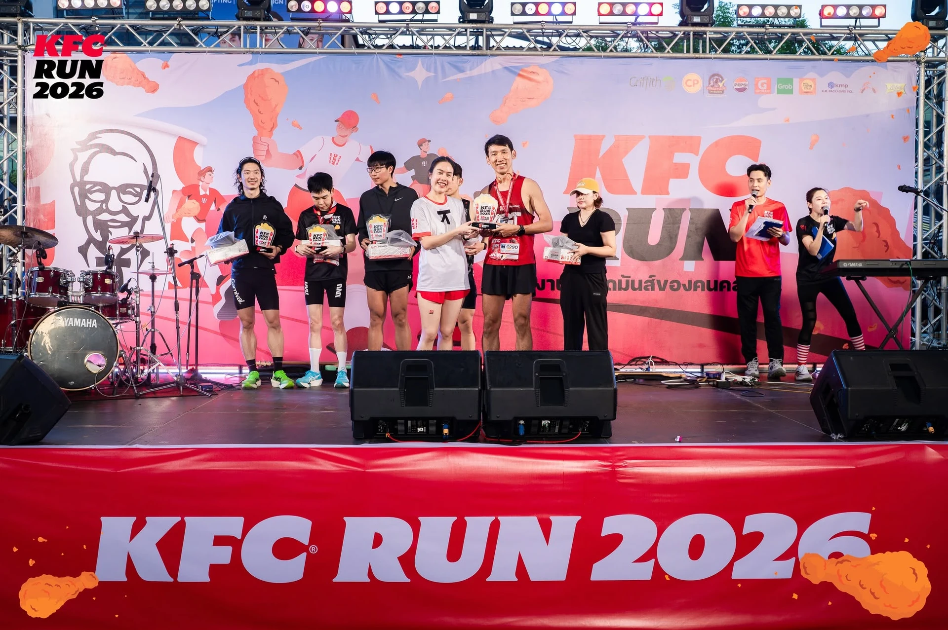 กลุ่มผู้ร่วมกิจกรรมถือรางวัลบนเวที KFC RUN 2026 จากโพสต์ไฮไลต์ของเพจงาน