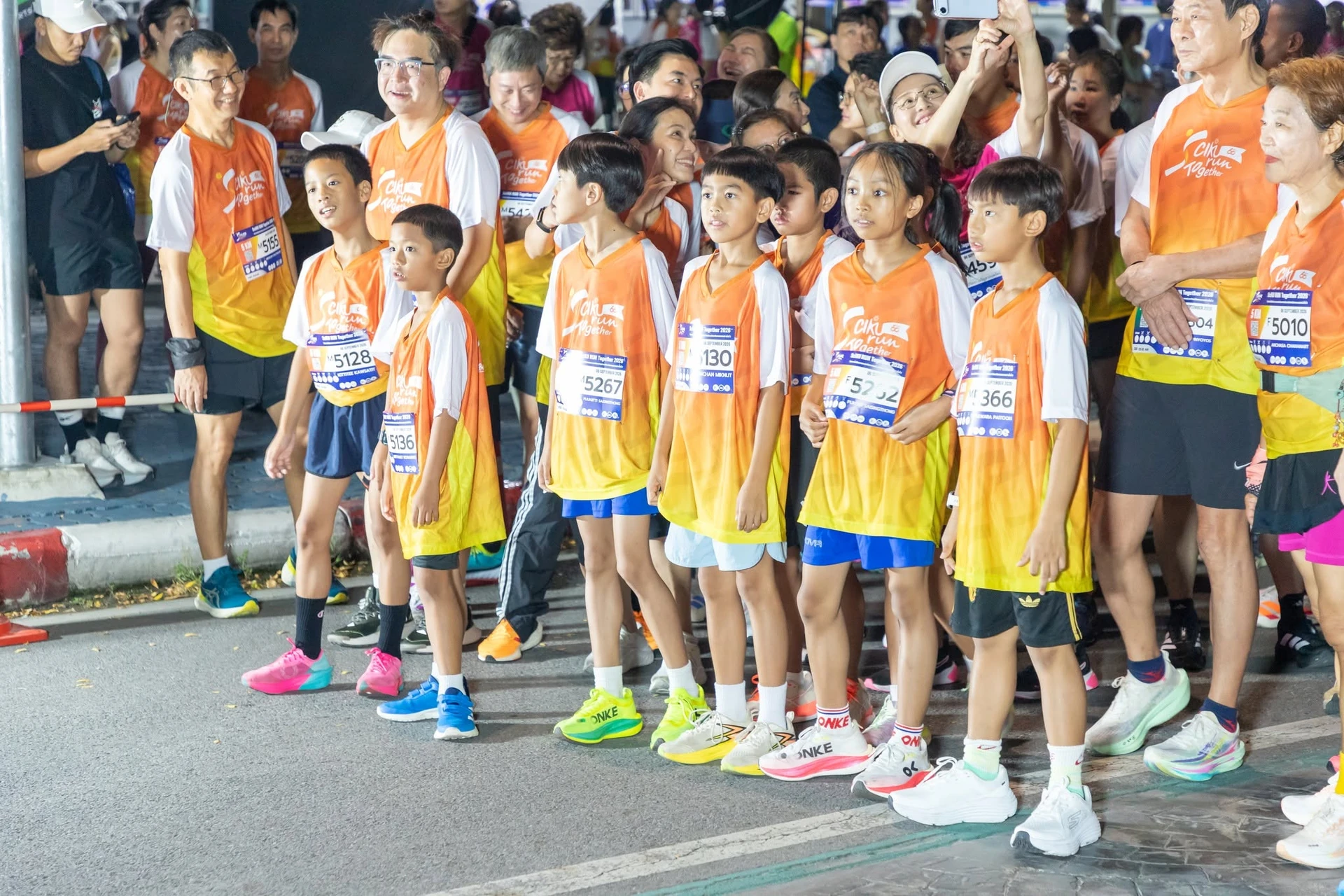 ผู้ร่วมกิจกรรมสวมเสื้องาน SciKU Run Together ยืนบริเวณแนวกั้น จากอัลบั้มรายงานงานเดียวกันของเพจคณะ