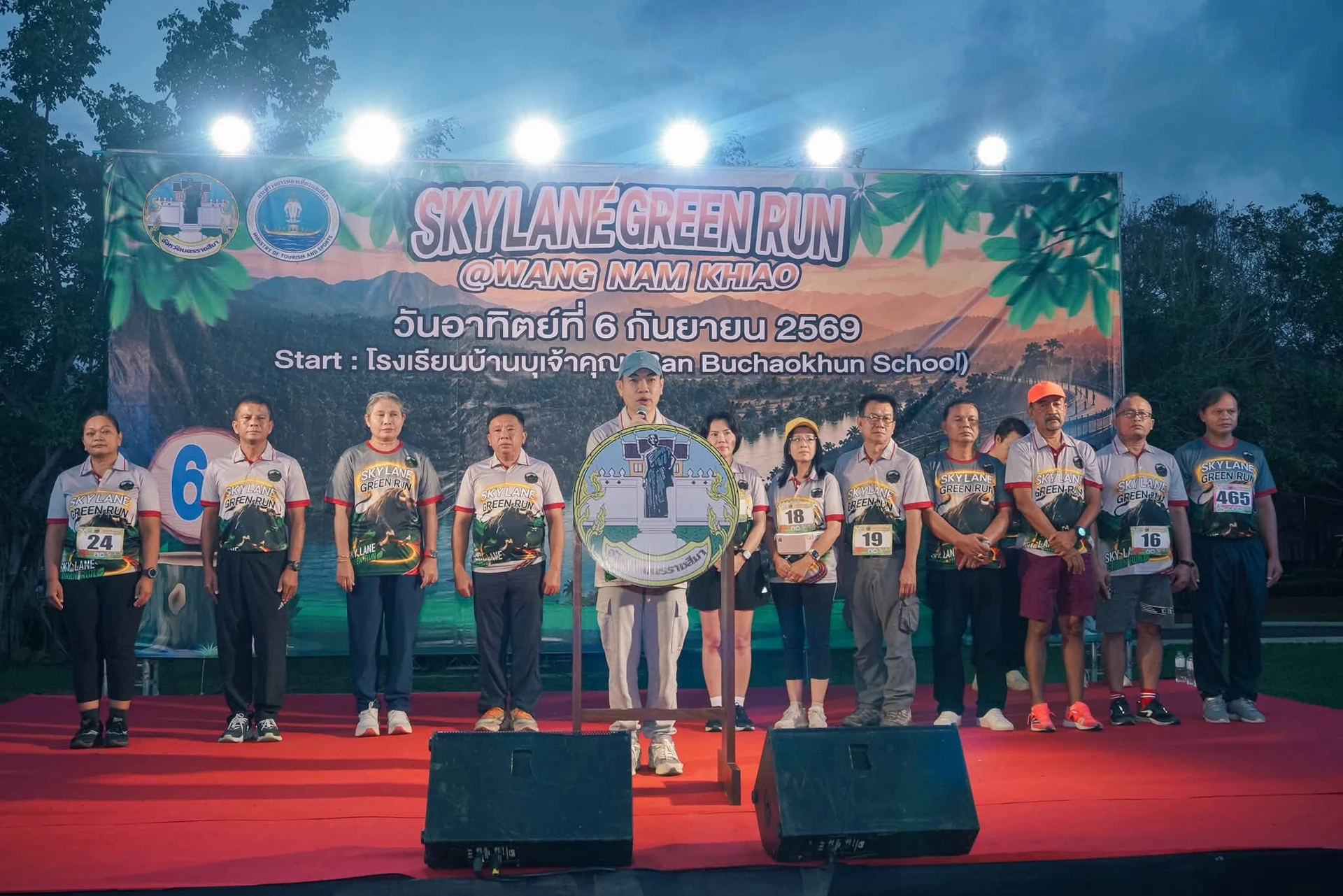 ผู้ร่วมงานยืนบนเวทีหน้าป้าย Sky Lane Green Run ซึ่งระบุวันที่ 6 กันยายน 2569 และโรงเรียนบ้านบุเจ้าคุณ จากโพสต์เพจงาน