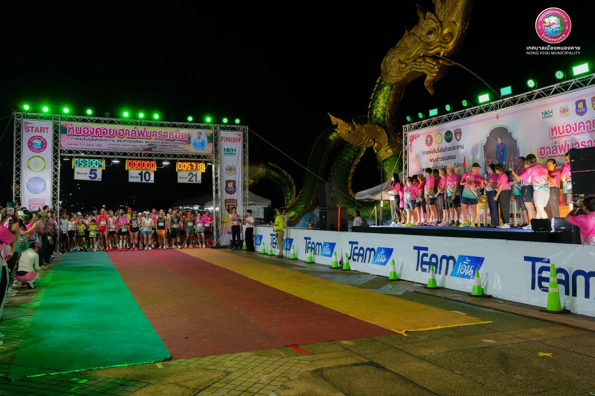 ผู้ร่วมกิจกรรมรอบซุ้ม START FINISH พร้อมเวทีและพญานาคคู่ริมโขง จากภาพลำดับสองในอัลบั้มเดียวกัน