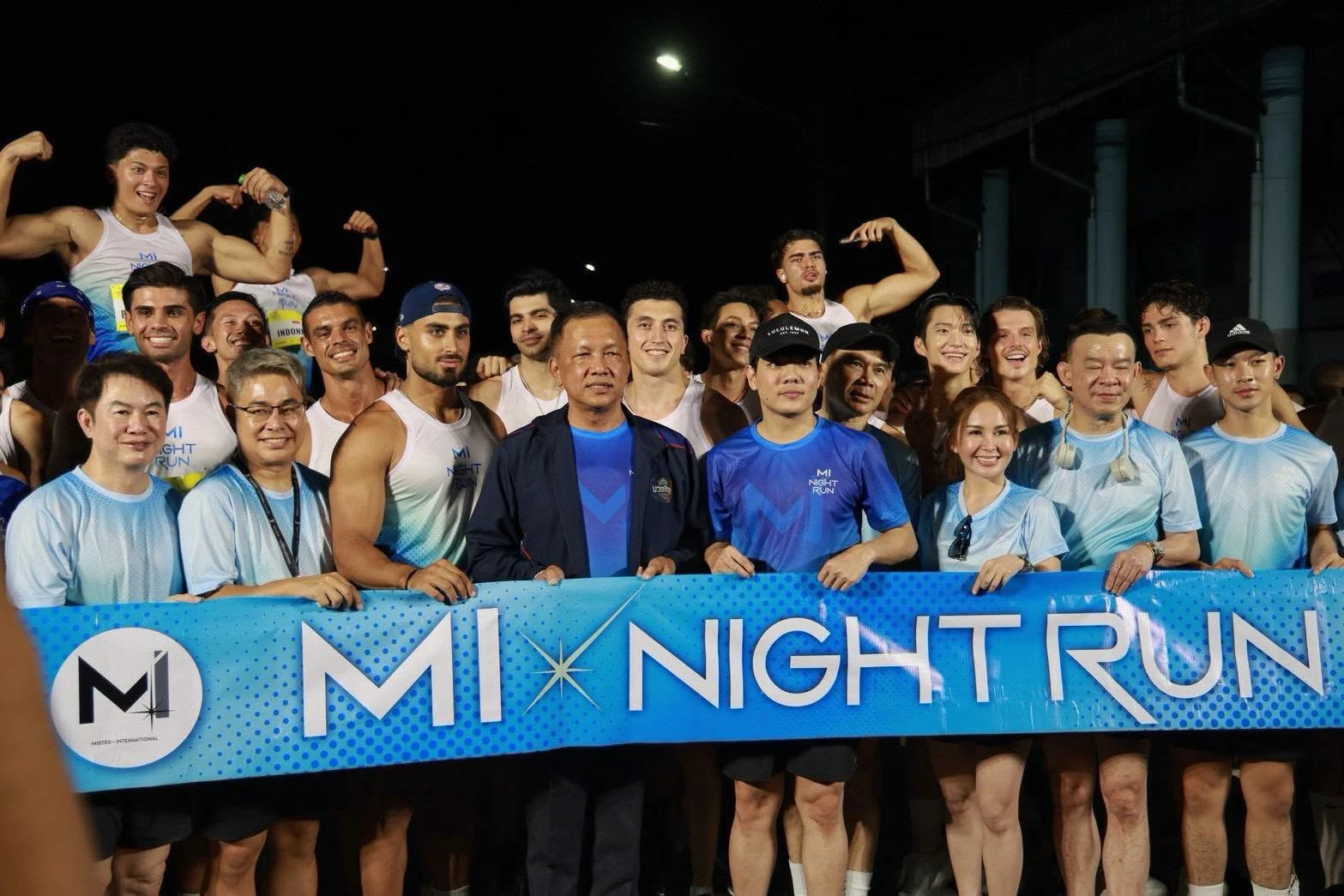 ผู้ร่วมกิจกรรมยืนรวมกลุ่มหลังป้าย MI NIGHT RUN ในภาพข่าวงานปี 2569