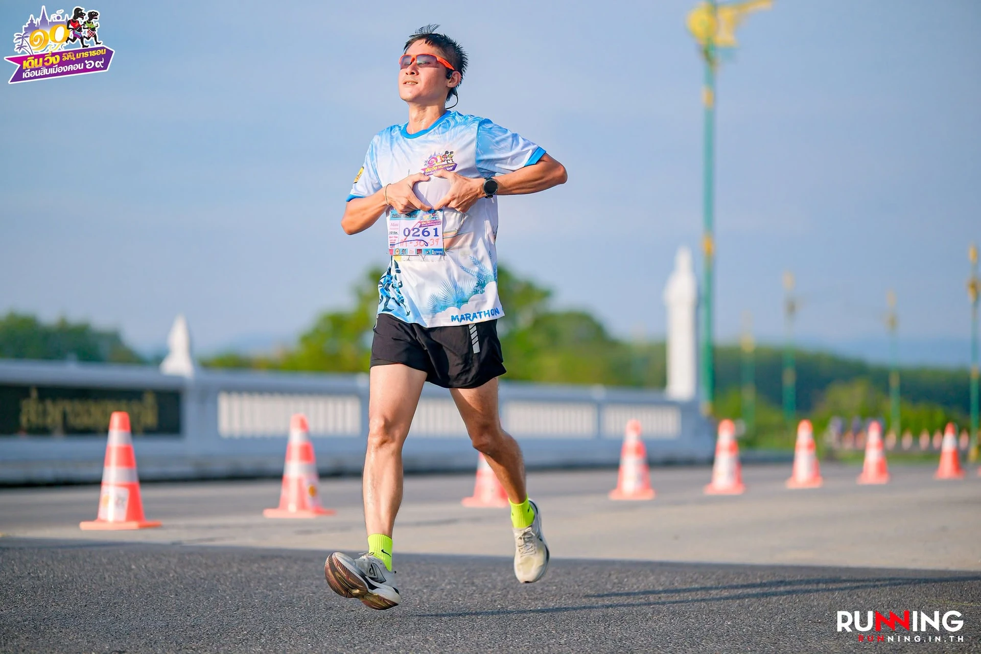 นักวิ่งบนทางวิ่งพร้อมตรางานเดือนสิบเมืองคอน 69 และเครดิต RUNNING.IN.TH