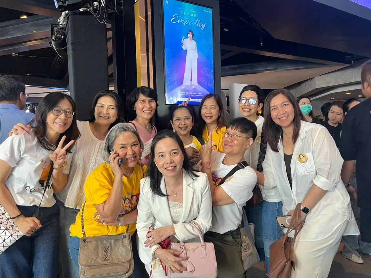 ผู้ร่วมงานถ่ายภาพกลุ่มบริเวณพื้นที่หน้าห้องพร้อมป้าย DJ. P’AOY One Stand Up Empathy ปี 2569