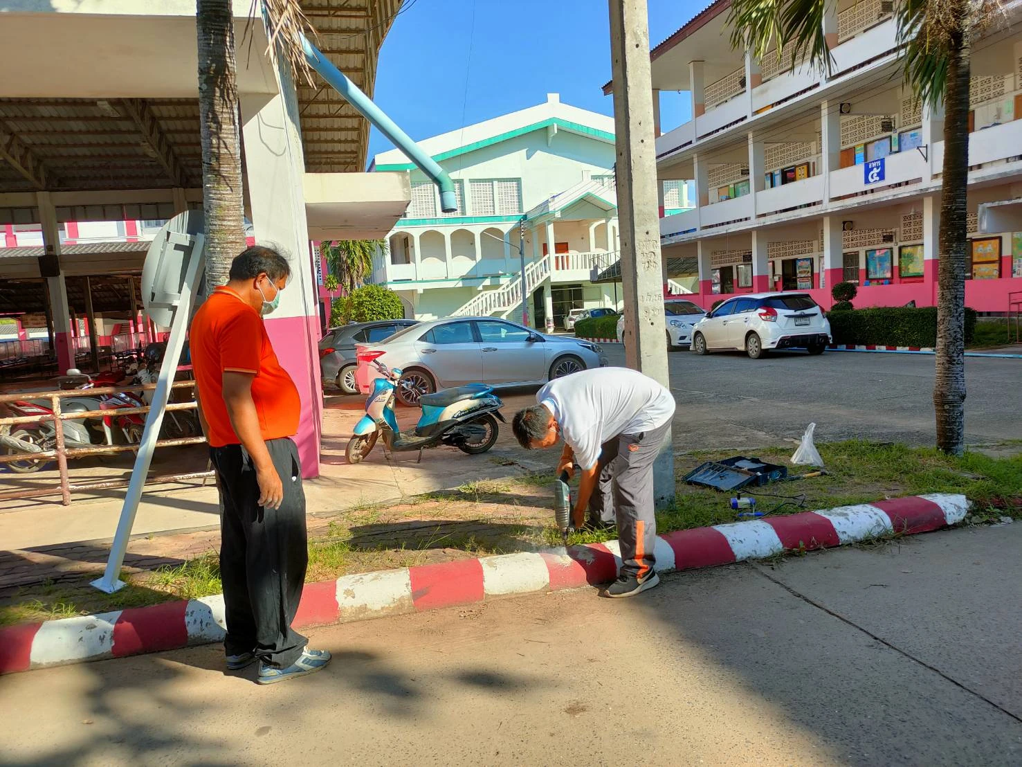 อาคารเรียนและถนนภายในโรงเรียนหนองบัววิทยายน มีผู้ติดตั้งป้ายจราจรอยู่ด้านหน้า