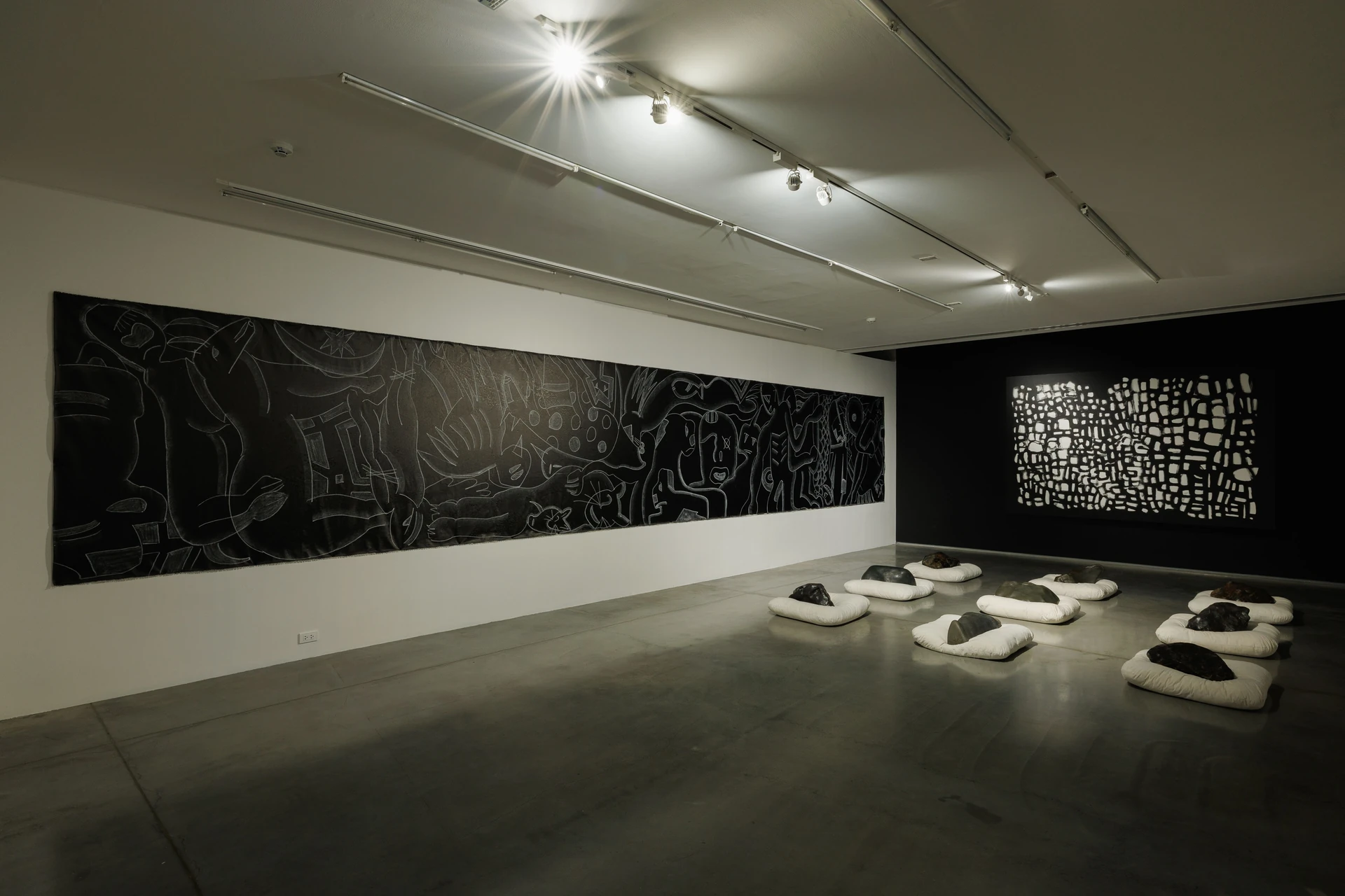 ผลงานบนผนังสองด้านและศิลปะจัดวางบนพื้นในห้อง BLACK