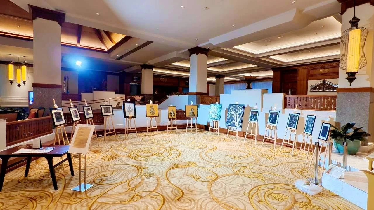 มุมกว้างพื้นที่จัดแสดง The Journey พร้อมผลงานบนขาตั้งในโรงแรม