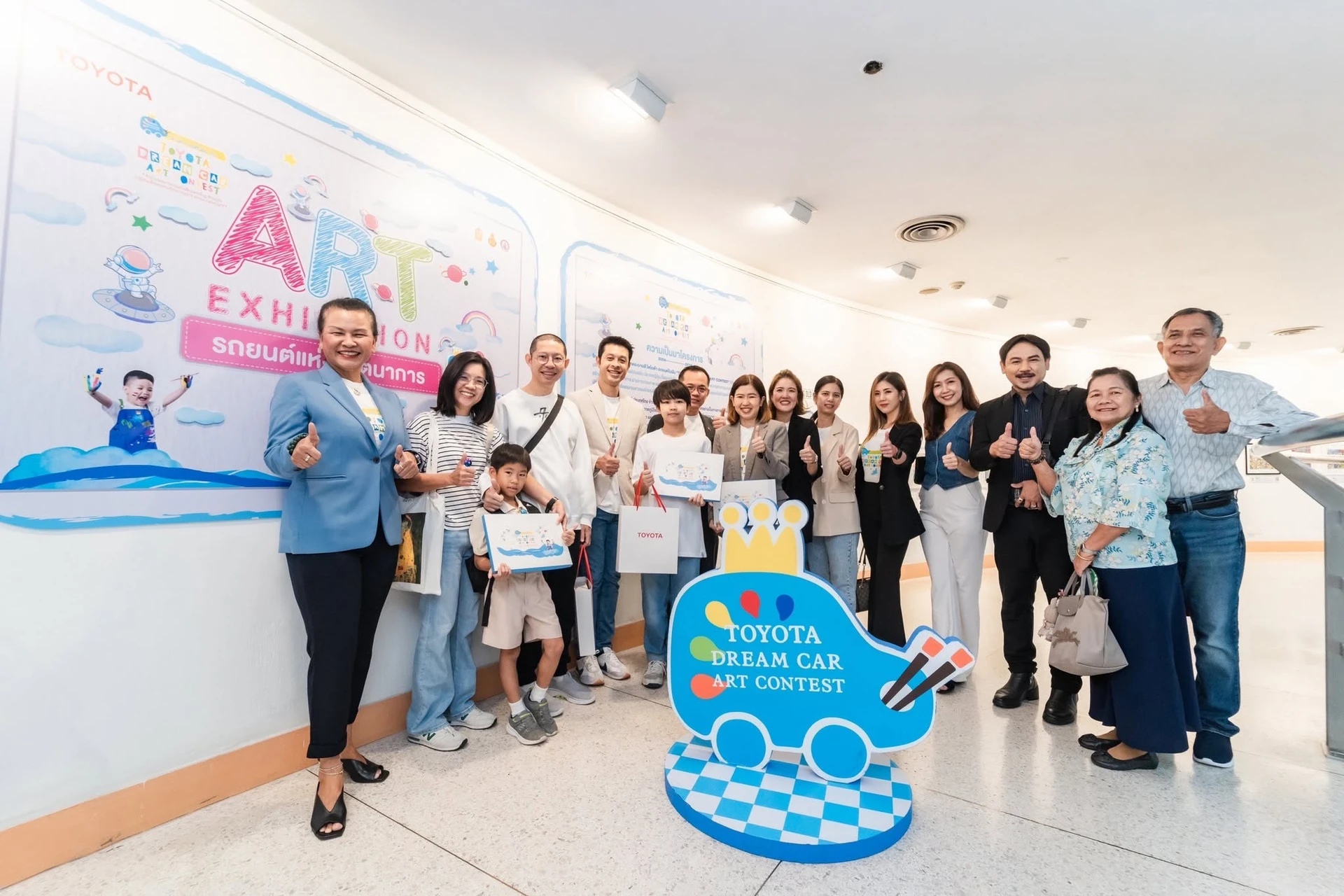 ผู้ร่วมกิจกรรมหน้าป้ายนิทรรศการรถยนต์แห่งจินตนาการในชุดภาพปี 2568