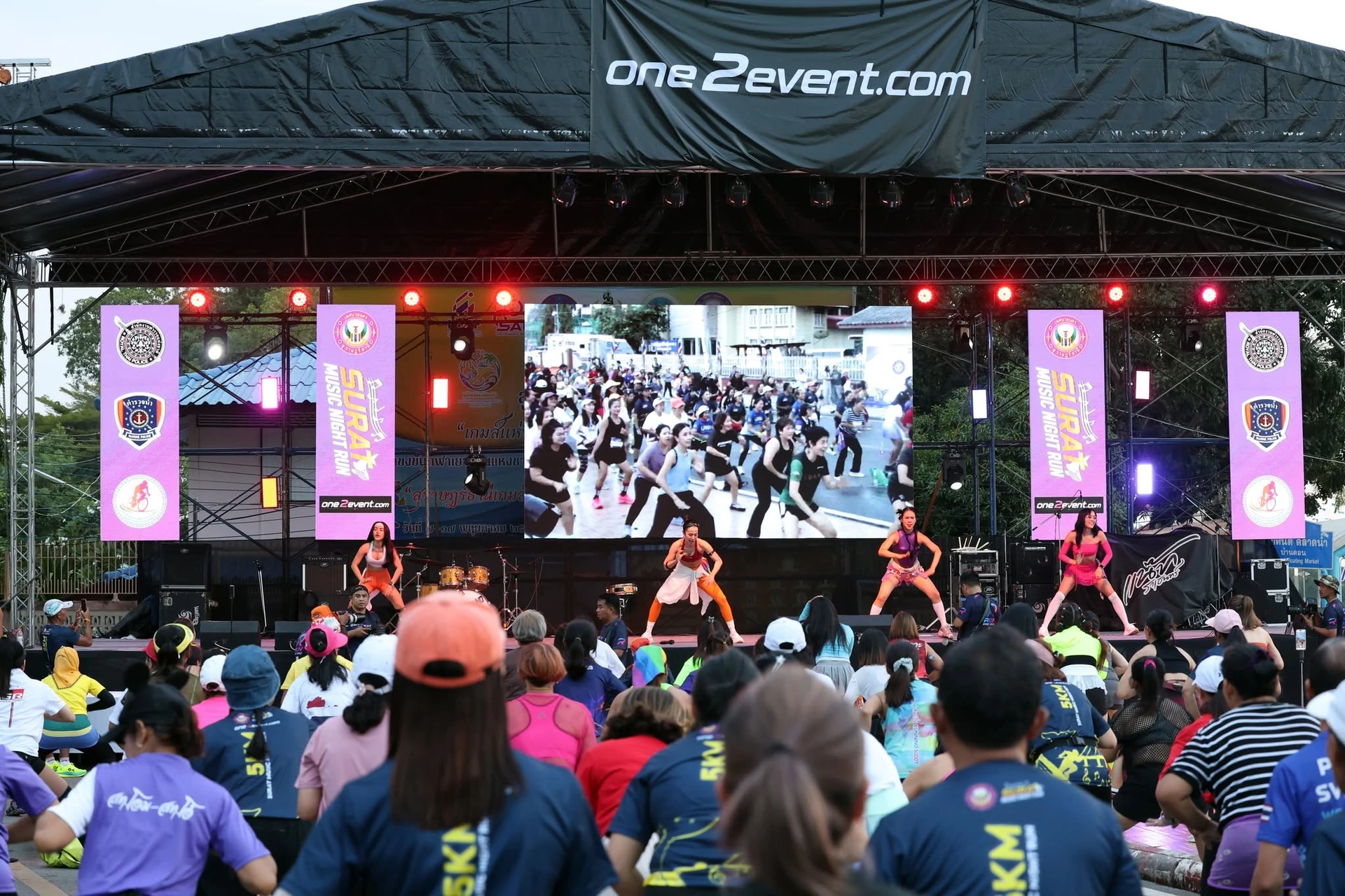 ผู้ร่วมกิจกรรมออกกำลังกายหน้าเวทีในชุดภาพ SURAT MUSIC NIGHT RUN 2026