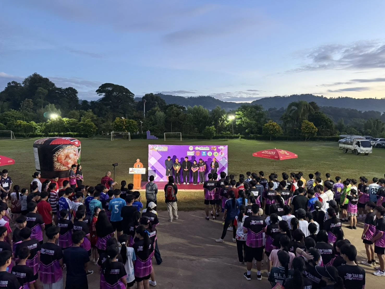 ผู้ร่วมกิจกรรมด้านหน้าเวที CAA 2025 Mini Marathon ในพื้นที่โรงเรียน