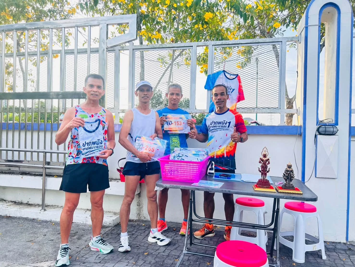 กลุ่มผู้ร่วมบูธประชาสัมพันธ์ปากพนัง 1 บริเวณโต๊ะและเสื้อกิจกรรม