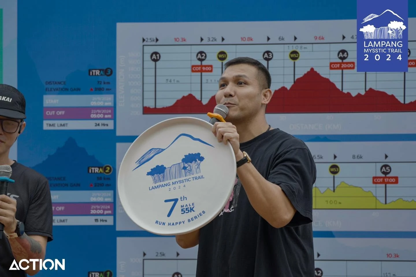 บรรยากาศผู้ถือไมโครโฟนหน้าแผนผังในกิจกรรมบรีฟ Lampang Mysstic Trail 2024