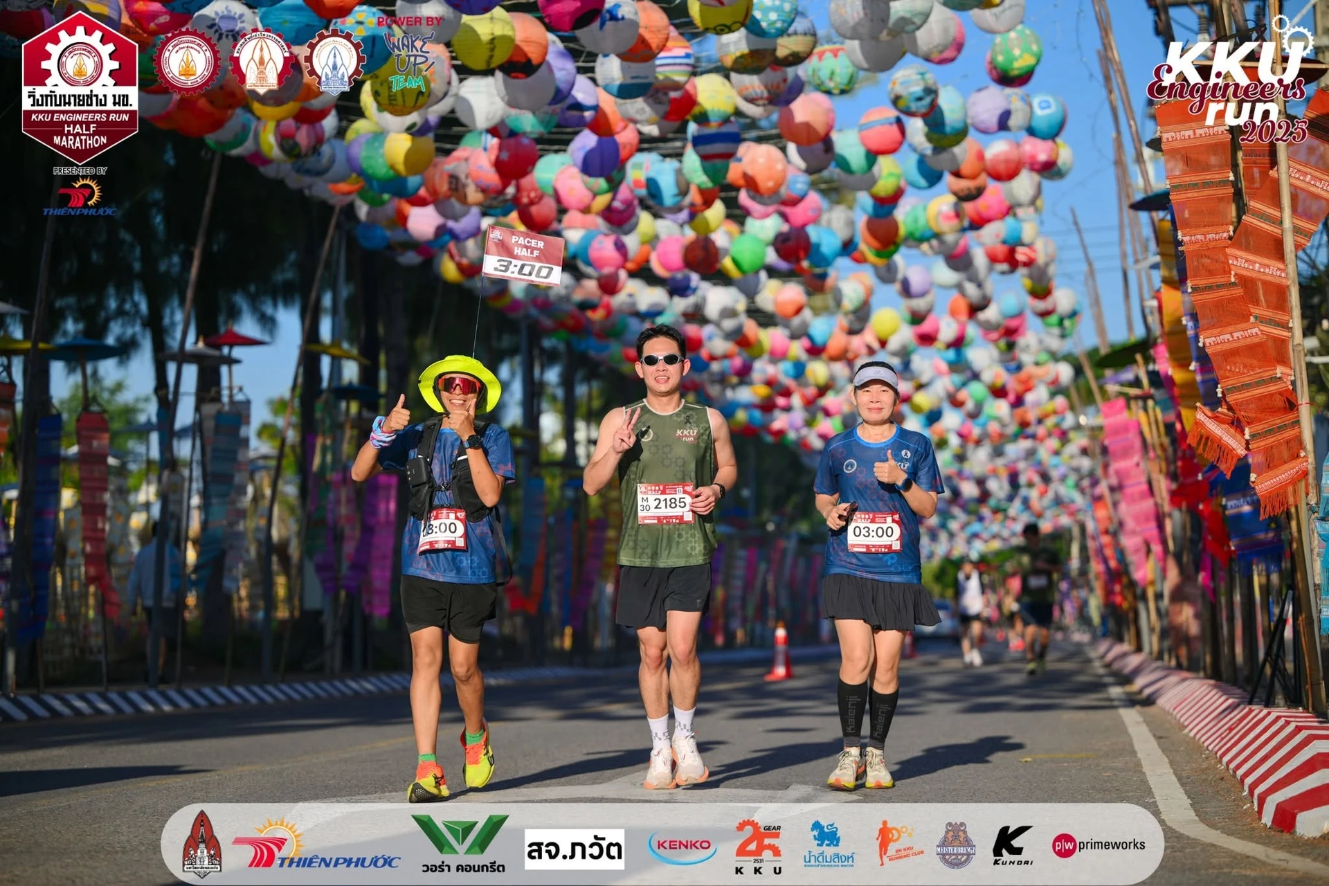 กลุ่มผู้ร่วมกิจกรรมบนถนนที่ตกแต่งด้วยโคมในอีกภาพจากชุดวิ่งกับนายช่าง มข. ปี 2568