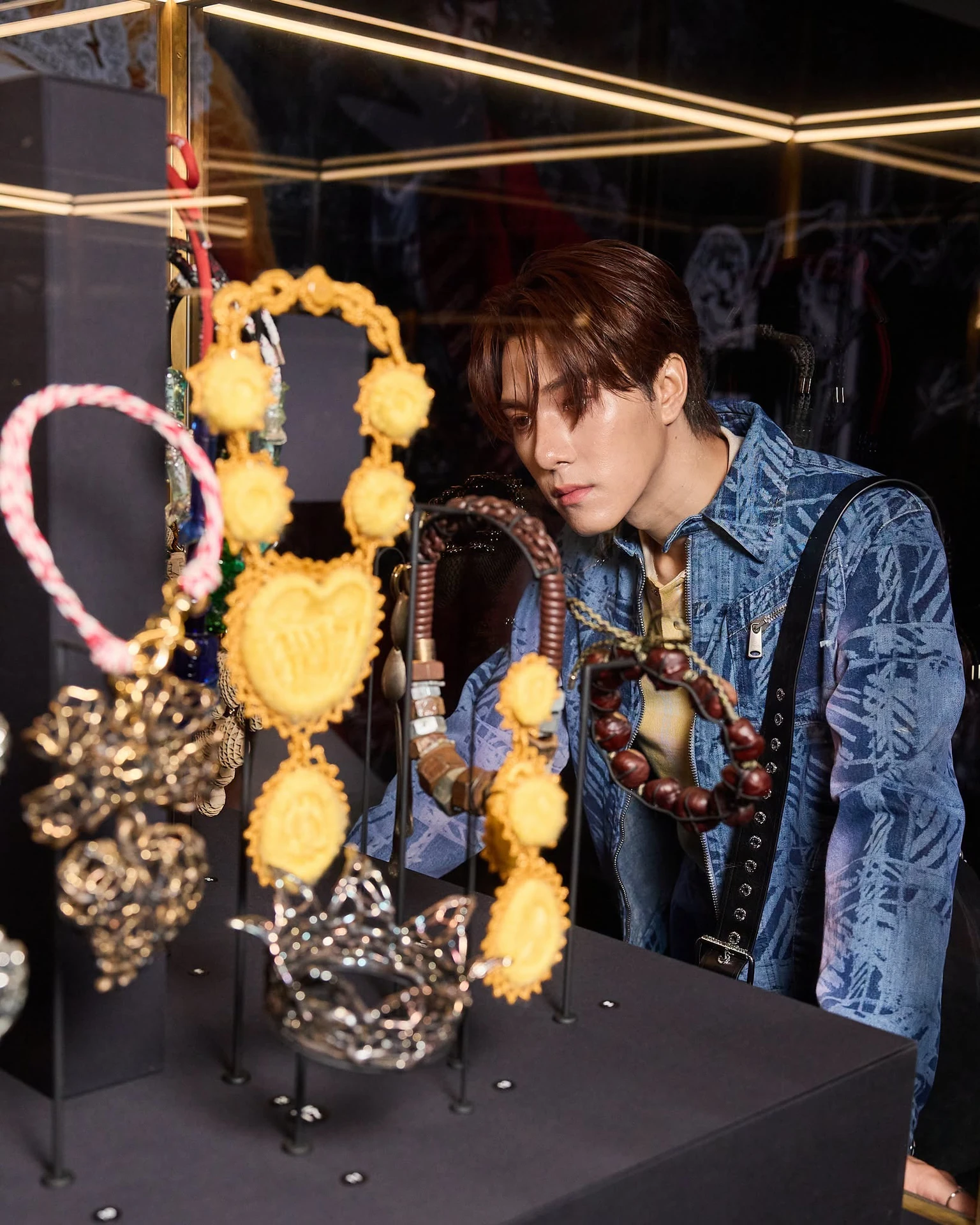 ภาพการชมเครื่องประดับในตู้จัดแสดงนิทรรศการ Vivienne Westwood & Jewellery ที่ผู้จัดเผยแพร่