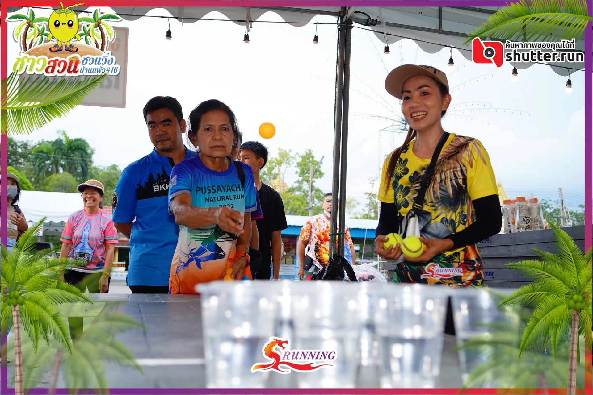 บรรยากาศกิจกรรมโยนลูกบอลบริเวณโต๊ะในเต็นท์ งานชาวสวนชวนวิ่ง บ้านแพ้วครั้งที่ 16 รอบปี 2566 คงภาพเต็มและตราต้นทาง