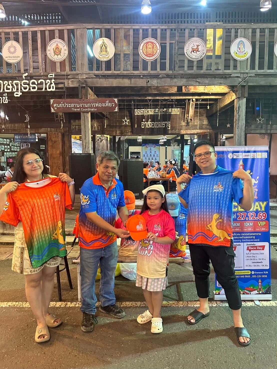 ภาพหมู่พร้อมเสื้อและหมวกหน้าจุดรับสมัคร จากรายงานกิจกรรมก่อนงานเขมราฐรันของเพจผู้จัด คงภาพเต็ม