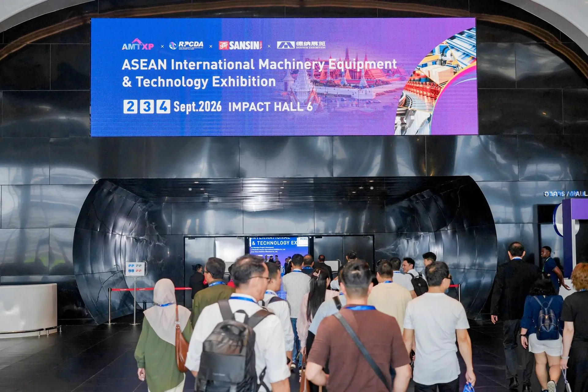 ผู้ร่วมงานบริเวณทางเข้าฮอลล์ใต้ป้าย ASEAN International Machinery Equipment & Technology Exhibition 2026 จากรายงานเปิดงานของ AMTXP คงภาพเต็ม