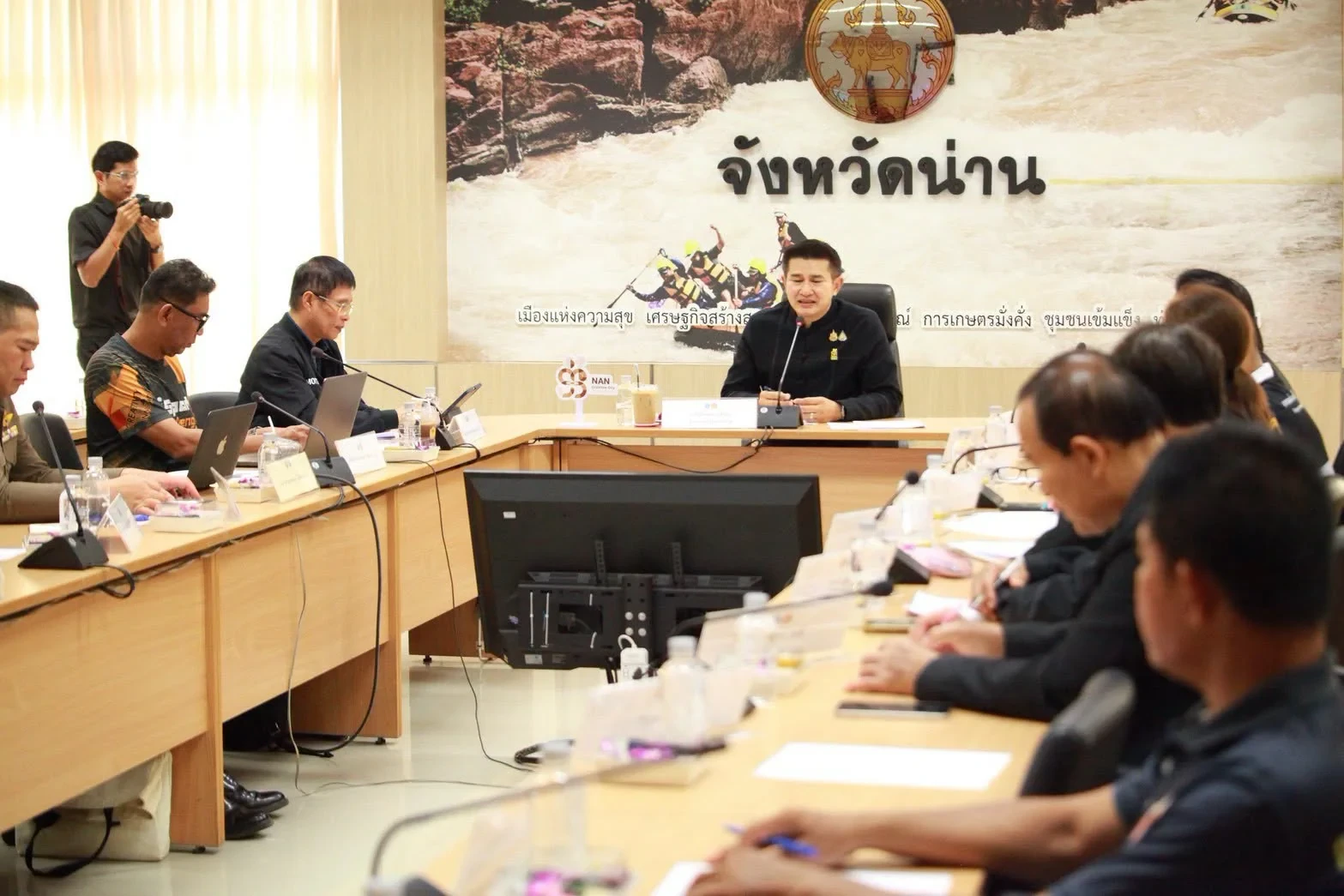 มุมกว้างห้องประชุมพร้อมผู้เข้าร่วมรอบโต๊ะ จากการประชุมคณะกรรมการเตรียมงาน Slow Life Night Run เมืองน่าน วันที่ 6 ตุลาคม 2569 คงภาพเต็ม