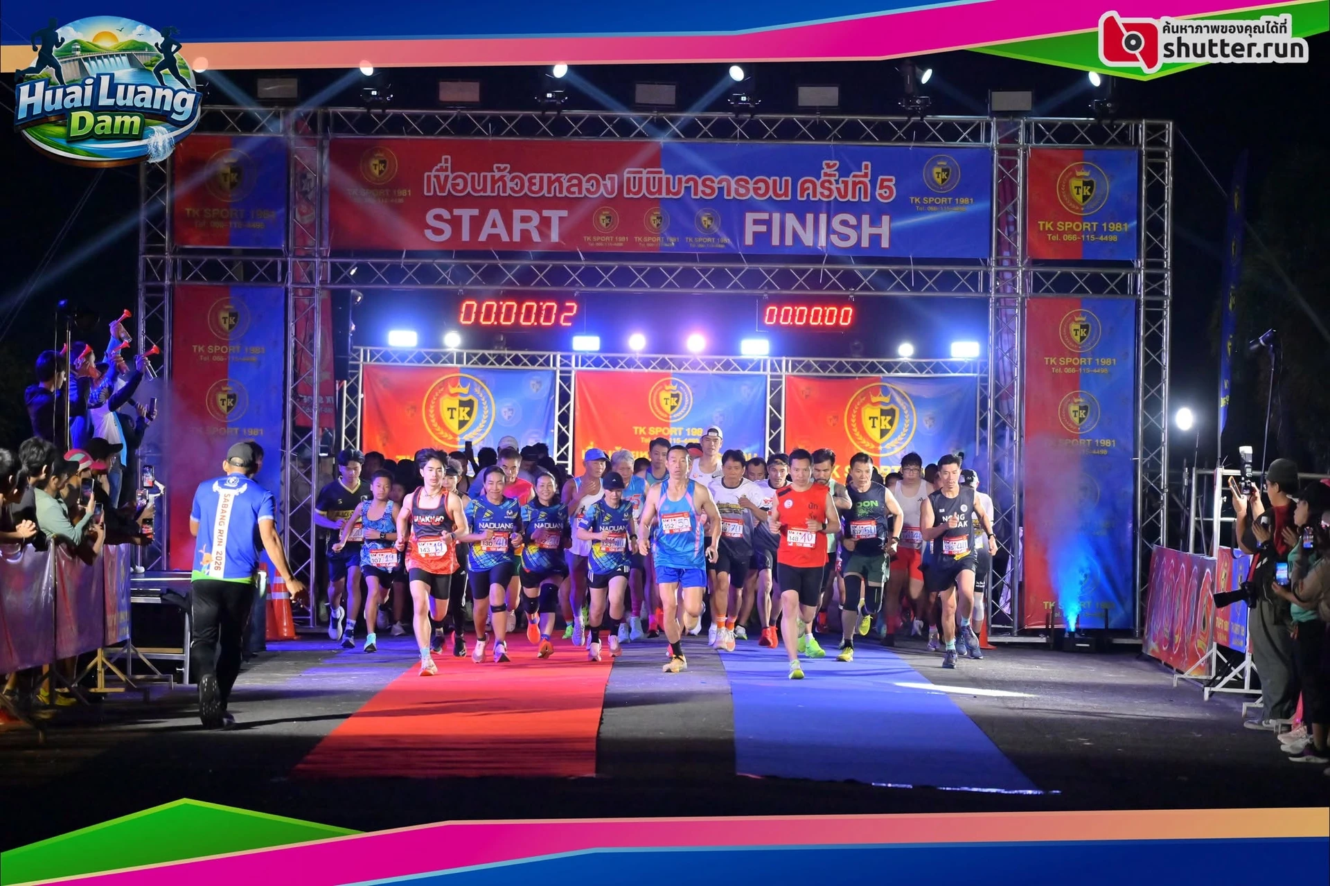 กลุ่มนักวิ่งบริเวณซุ้ม START FINISH ที่มีป้ายเขื่อนห้วยหลวง มินิมาราธอน ครั้งที่ 5 จากโพสต์ ThaiPhotorun คงภาพเต็มและลายน้ำ
