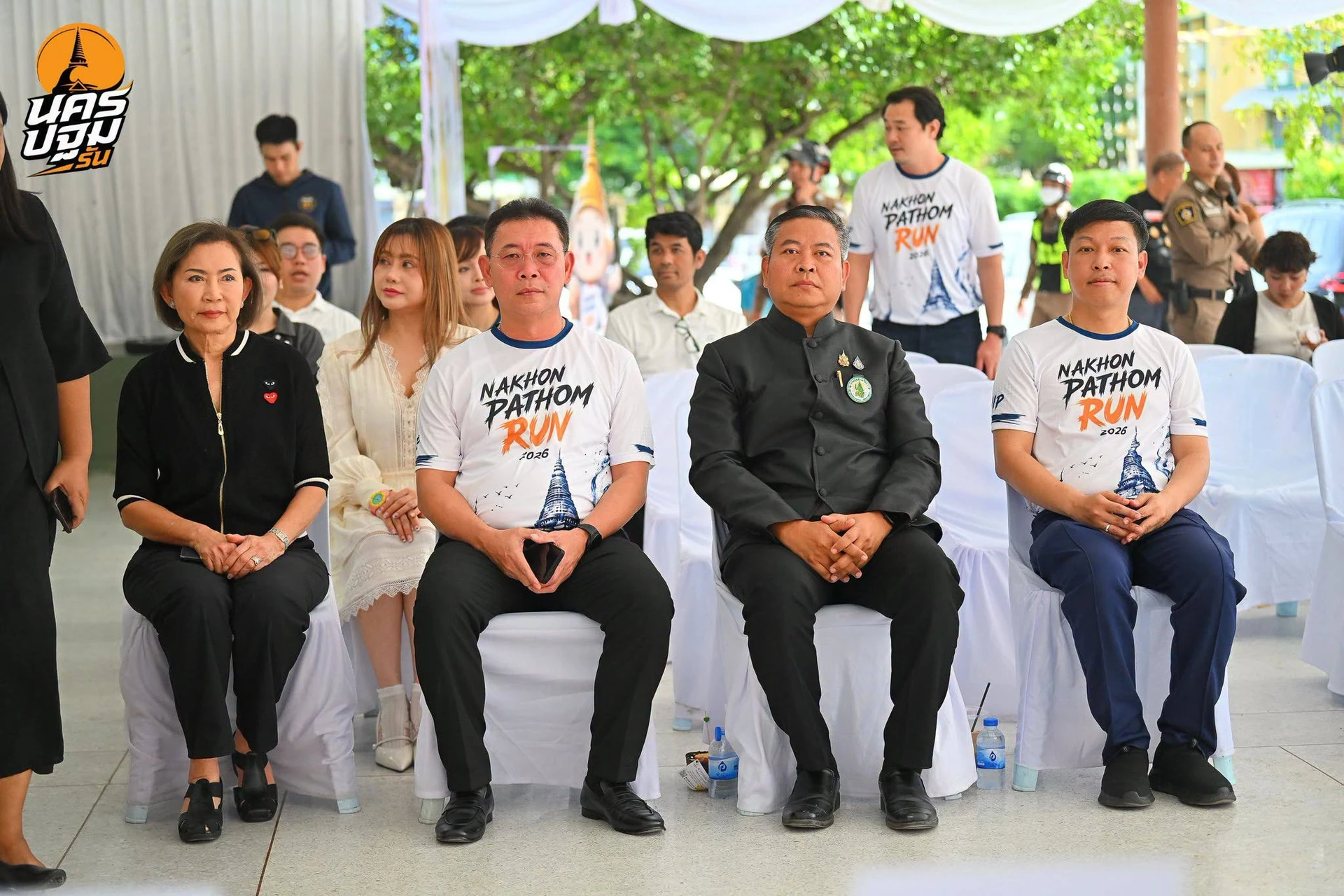 กลุ่มผู้ร่วมงานนั่งในบริเวณแถลงข่าวนครปฐมรัน วันที่ 3 กรกฎาคม 2569 ตามรายงาน Pixme.photos คงภาพเต็มและตรางาน