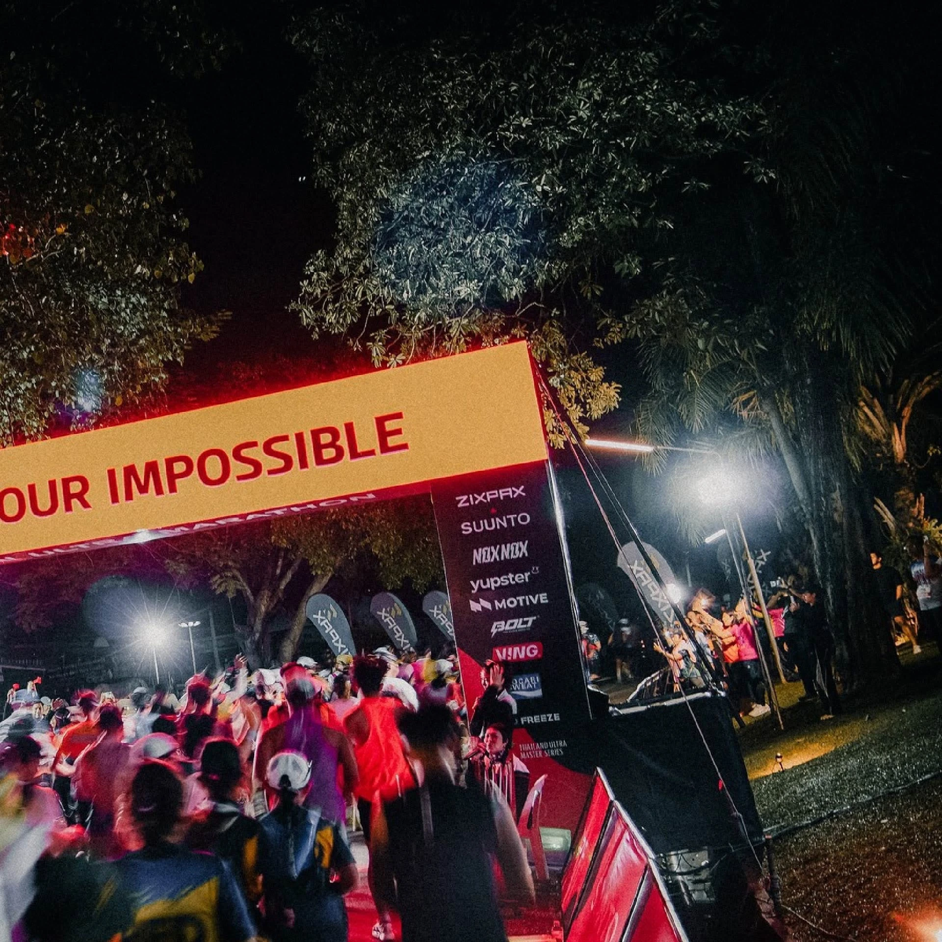 ภาพนักวิ่งบริเวณซุ้มที่มีข้อความ Start Your Impossible ในเวลากลางคืน จากเพจ Khaoyai 100K
