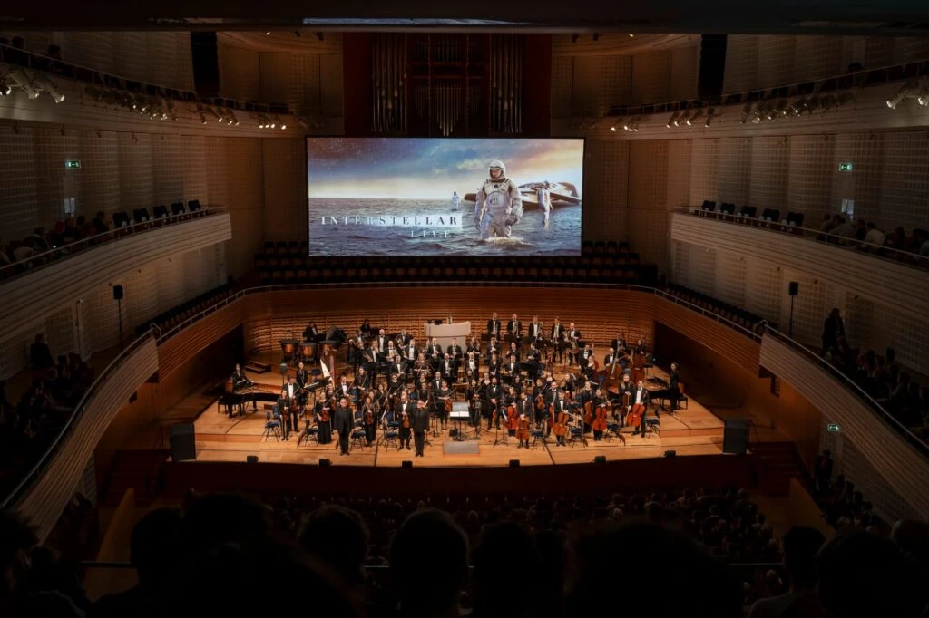 ภาพเวทีวงออร์เคสตราและจอภาพยนตร์ Interstellar Live ที่ KKL Luzern สวิตเซอร์แลนด์ วันที่ 6 ธันวาคม 2568