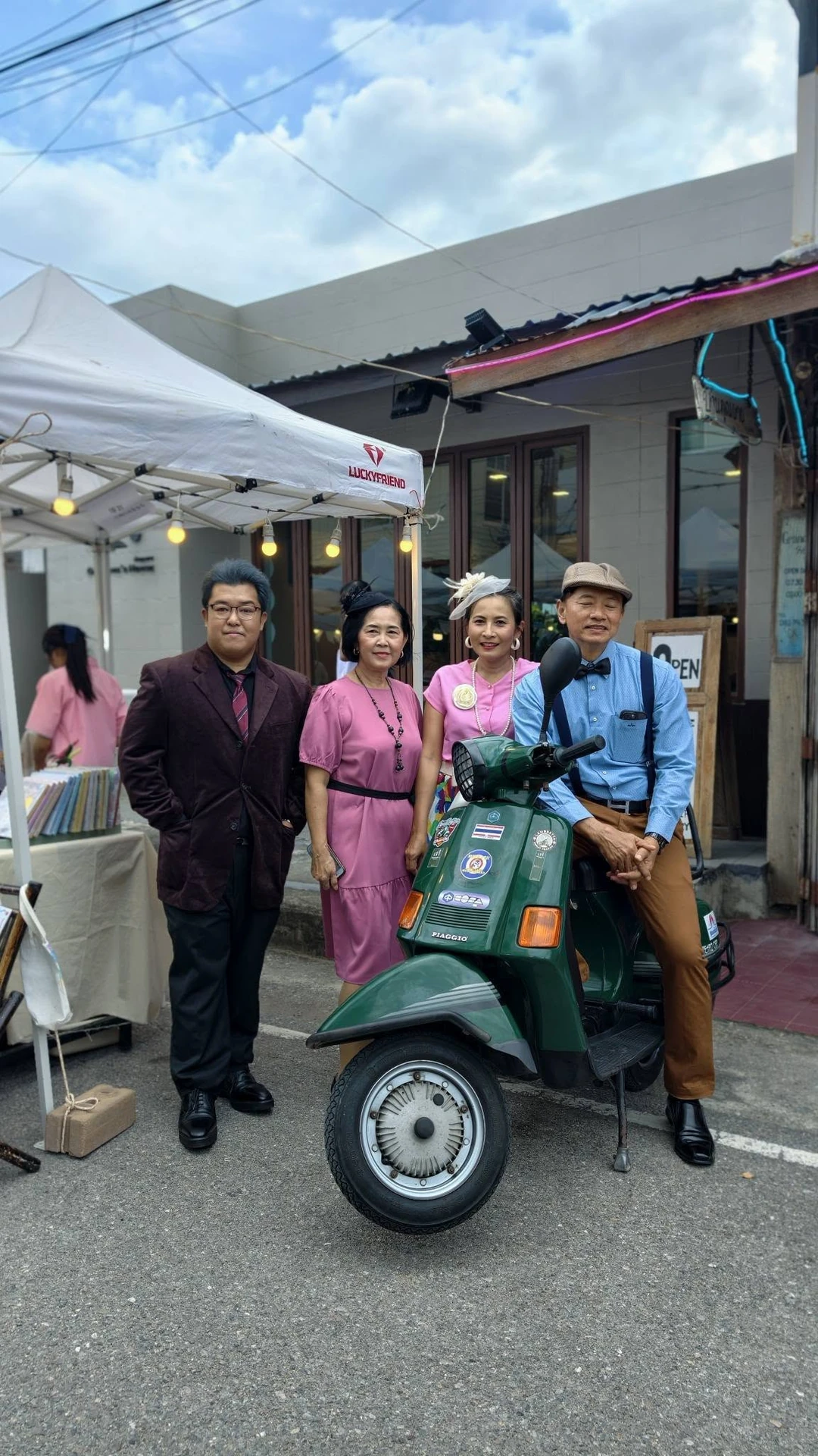 บรรยากาศจุดบันทึกภาพข้างรถสกูตเตอร์และร้านค้าในงานสู้ศึก ต้นทางไม่ระบุปีถ่าย