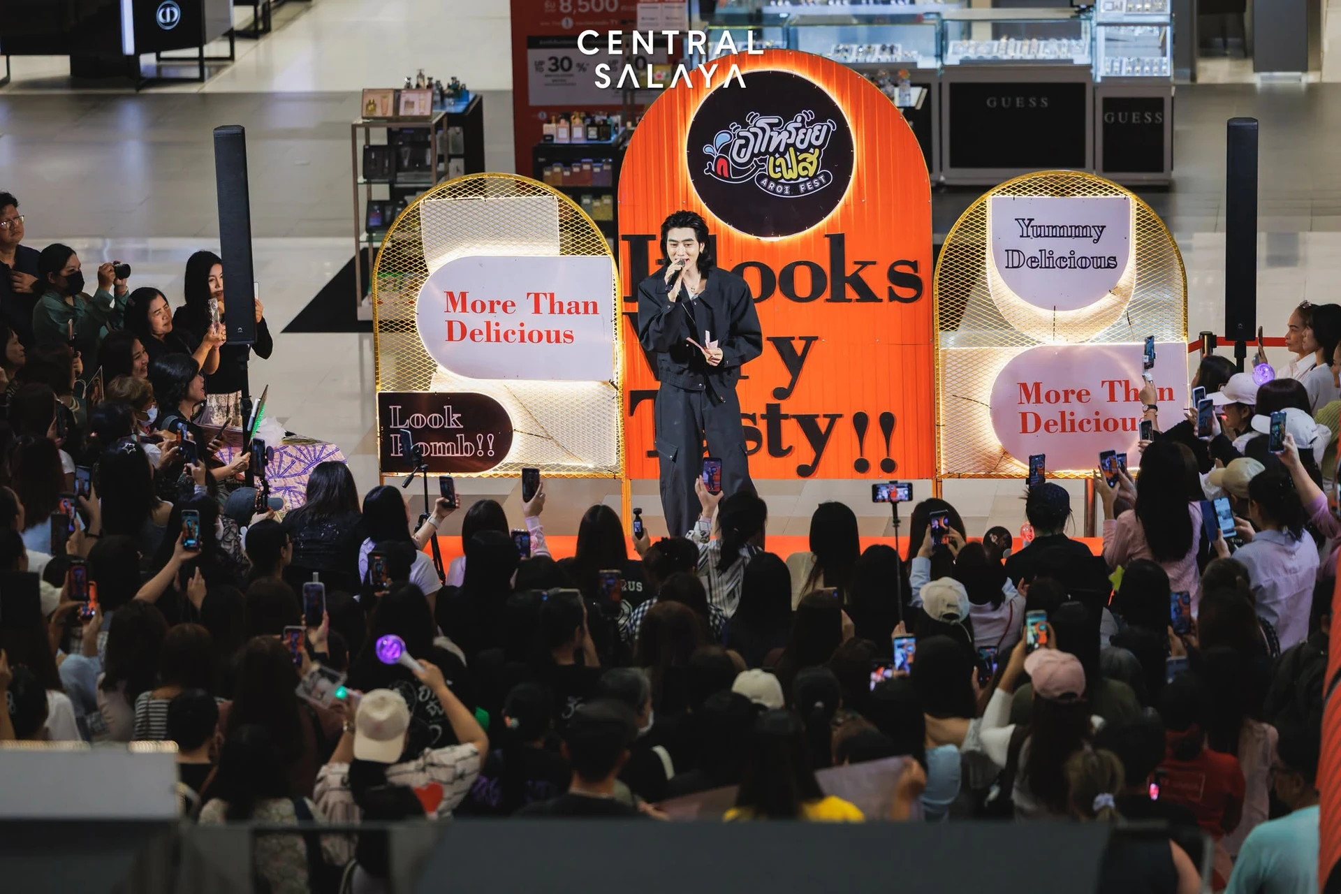 เวทีพร้อมป้ายอาโหร่ยยเฟสและผู้คนโดยรอบที่เซ็นทรัลศาลายา ปี 2569