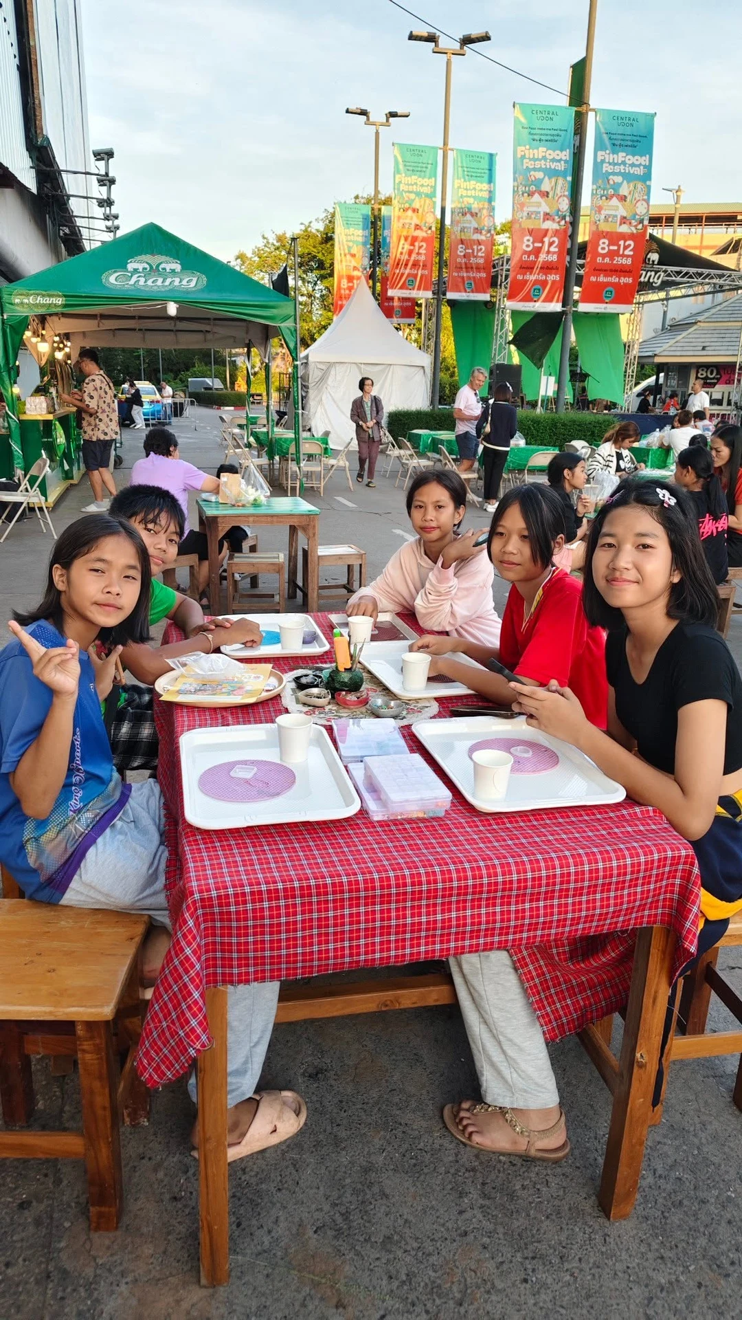 ผู้คนรอบโต๊ะพร้อมถาดและวัสดุเวิร์กช็อป หน้าเซ็นทรัลอุดร โดยป้ายในพื้นที่ระบุ FinFood Festival ปี 2568