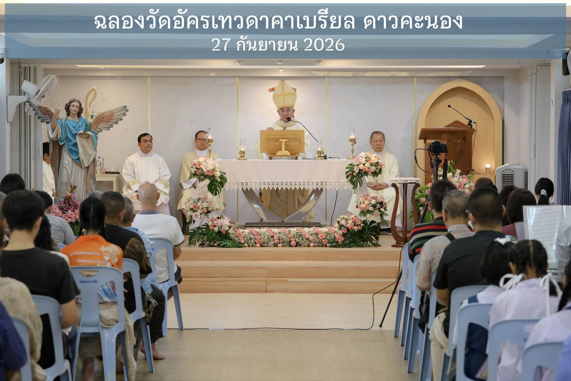 บริเวณด้านหน้าและแถวที่นั่งภายในวัดอัครเทวดาคาเบรียล ดาวคะนอง พร้อมข้อความชื่อกิจกรรมและวันที่ 27 กันยายน 2026 จากต้นทาง