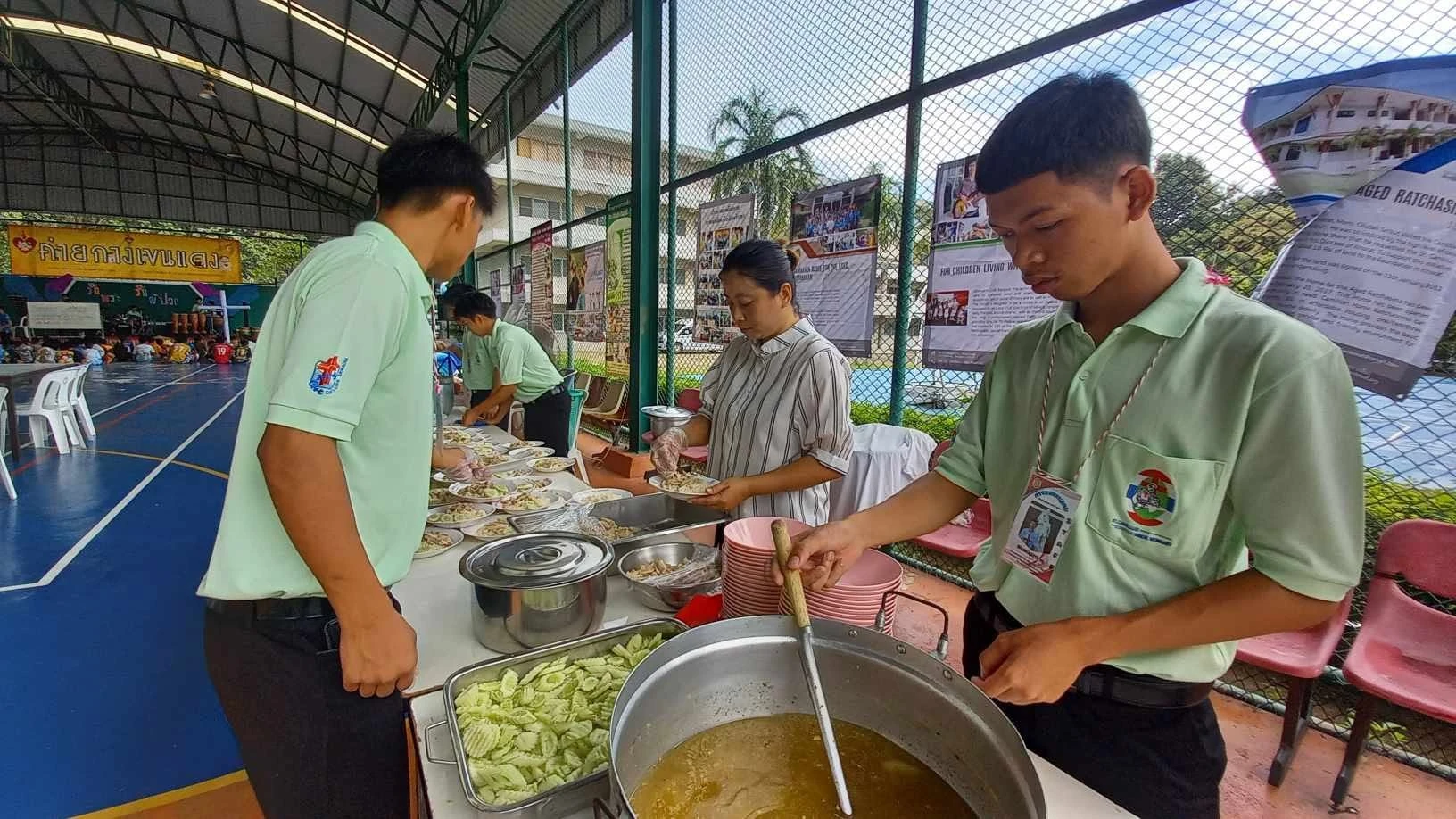 ผู้คนบริเวณโต๊ะเตรียมอาหาร พร้อมหม้อและภาชนะ จากรายงานช่วยเตรียมค่ายกางเขนแดงปี 2567