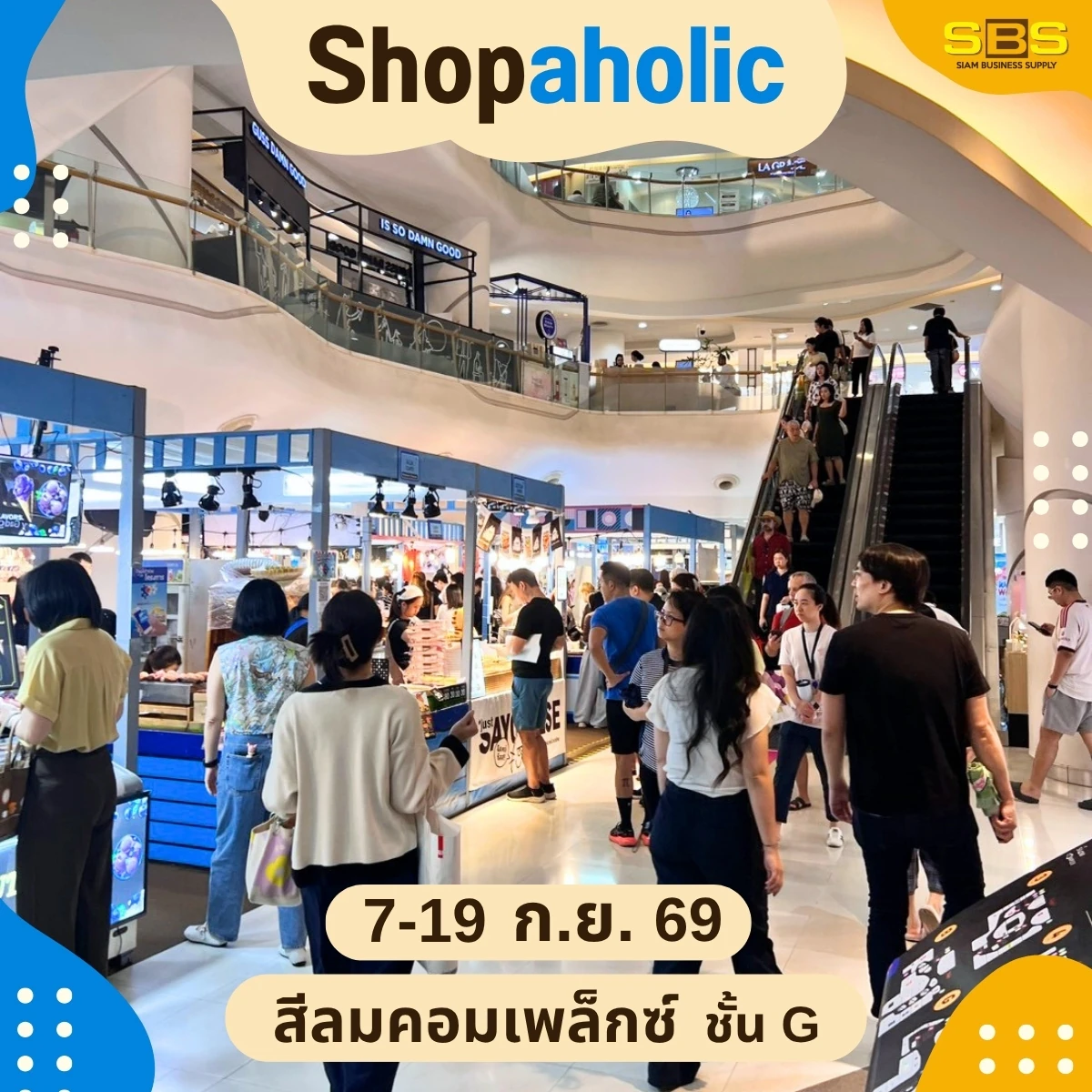 บูธสินค้าและผู้คนใกล้บันไดเลื่อน ในภาพประกอบประชาสัมพันธ์ Shopaholic สีลมคอมเพล็กซ์ของ SBS Event ที่ไม่ระบุวันถ่าย