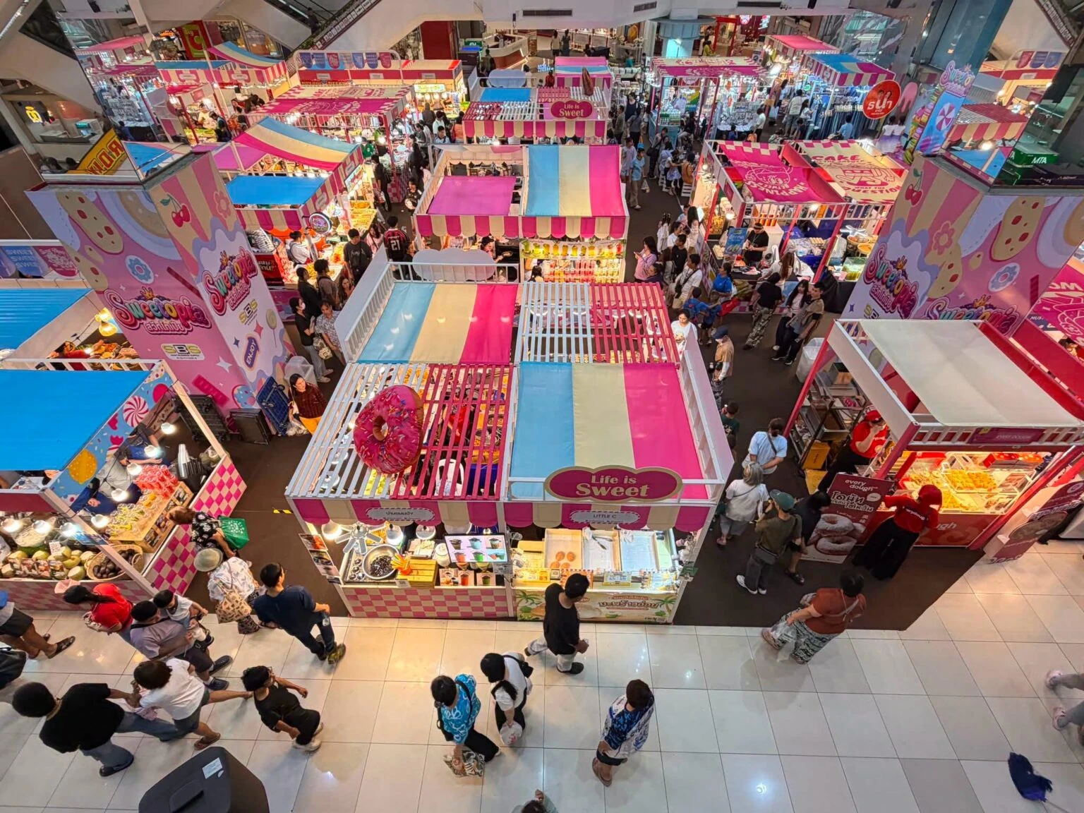 มุมสูงของบูธและทางเดินที่มีป้าย Sweetopia ภาพที่ SBS Event ใช้ประกอบประชาสัมพันธ์ ไม่ระบุวันถ่าย