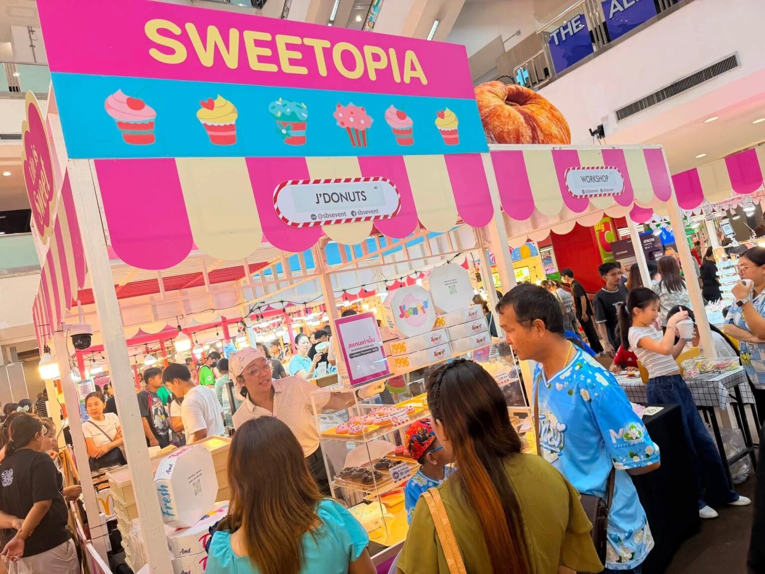 บูธขนมใต้ป้าย Sweetopia และผู้คน ภาพที่ SBS Event ใช้ประกอบประชาสัมพันธ์ ไม่ระบุวันถ่าย