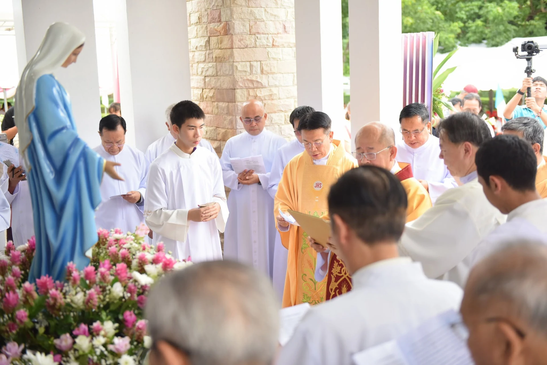 ผู้คนบริเวณพระรูปที่ตกแต่งดอกไม้ จากรายงานฉลองวัดมารีสมภพ กบินทร์บุรี ปี 2569